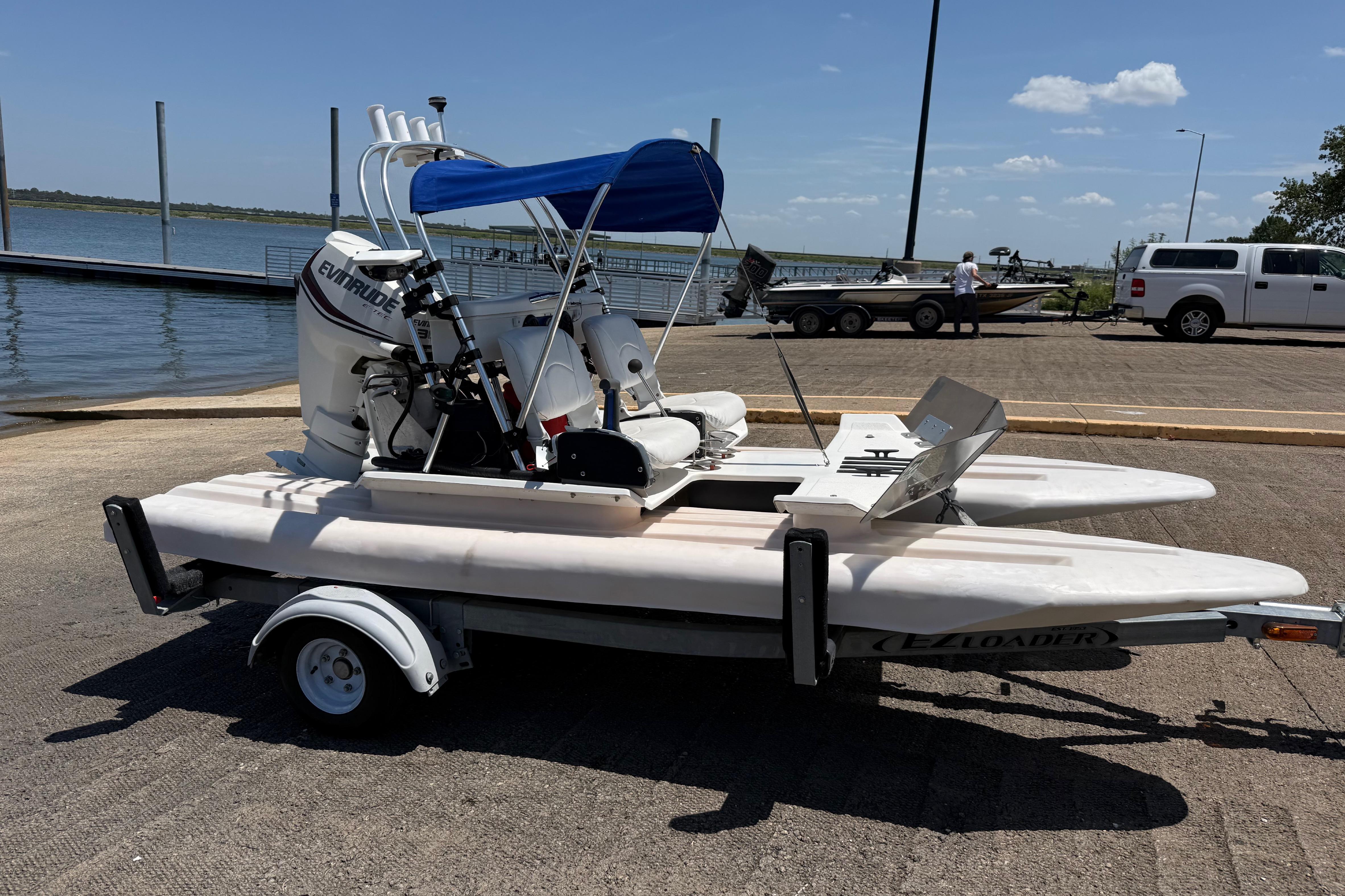 2016 CraigCat E2 Elite catamaran on trailer by a lakeside dock.