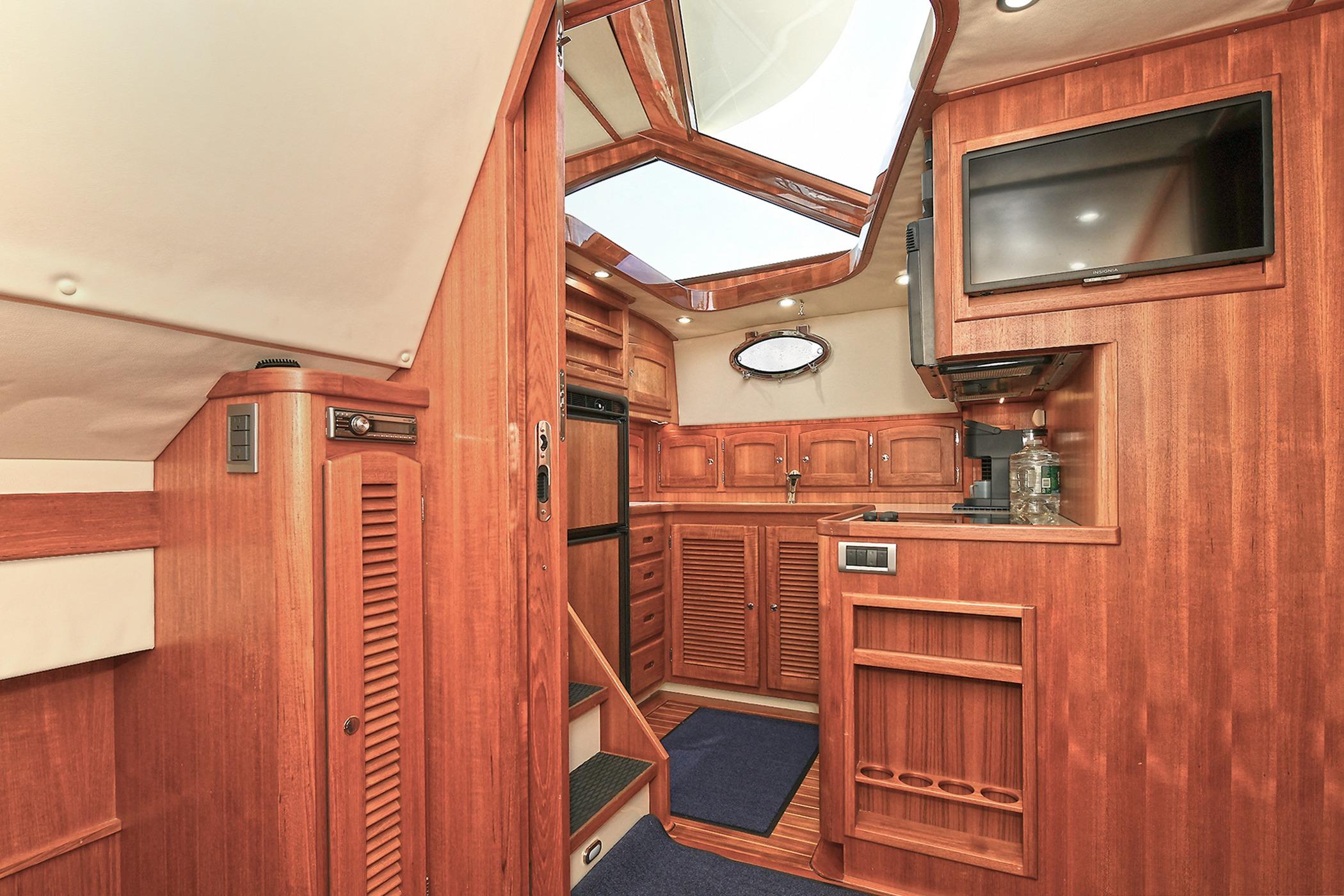 Luxurious 2005 San Juan Downeast Express yacht interior with wood paneling and modern amenities.