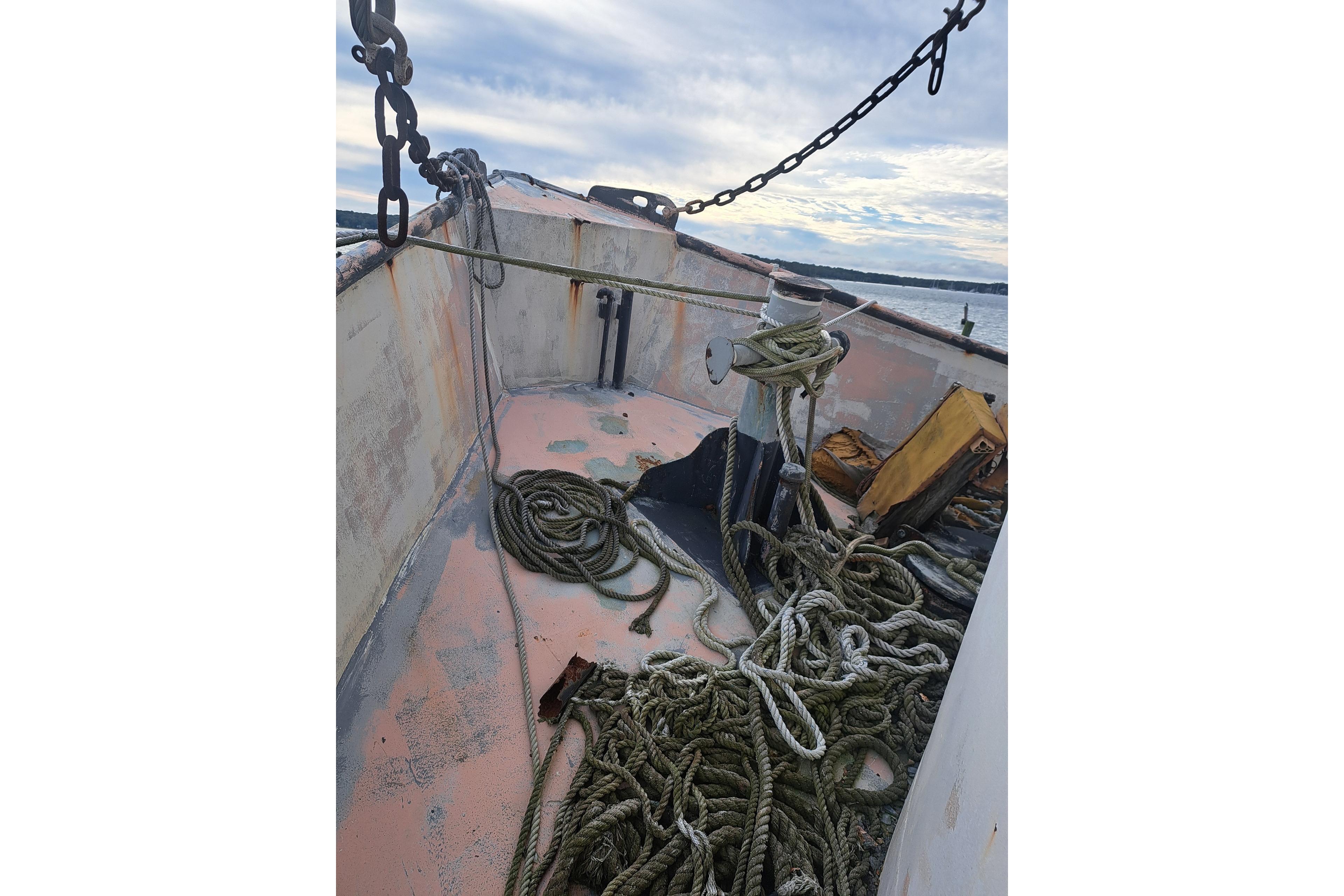 Deck of 1979 Custom Steel Trawler Dragger with ropes and chains, under a cloudy sky.