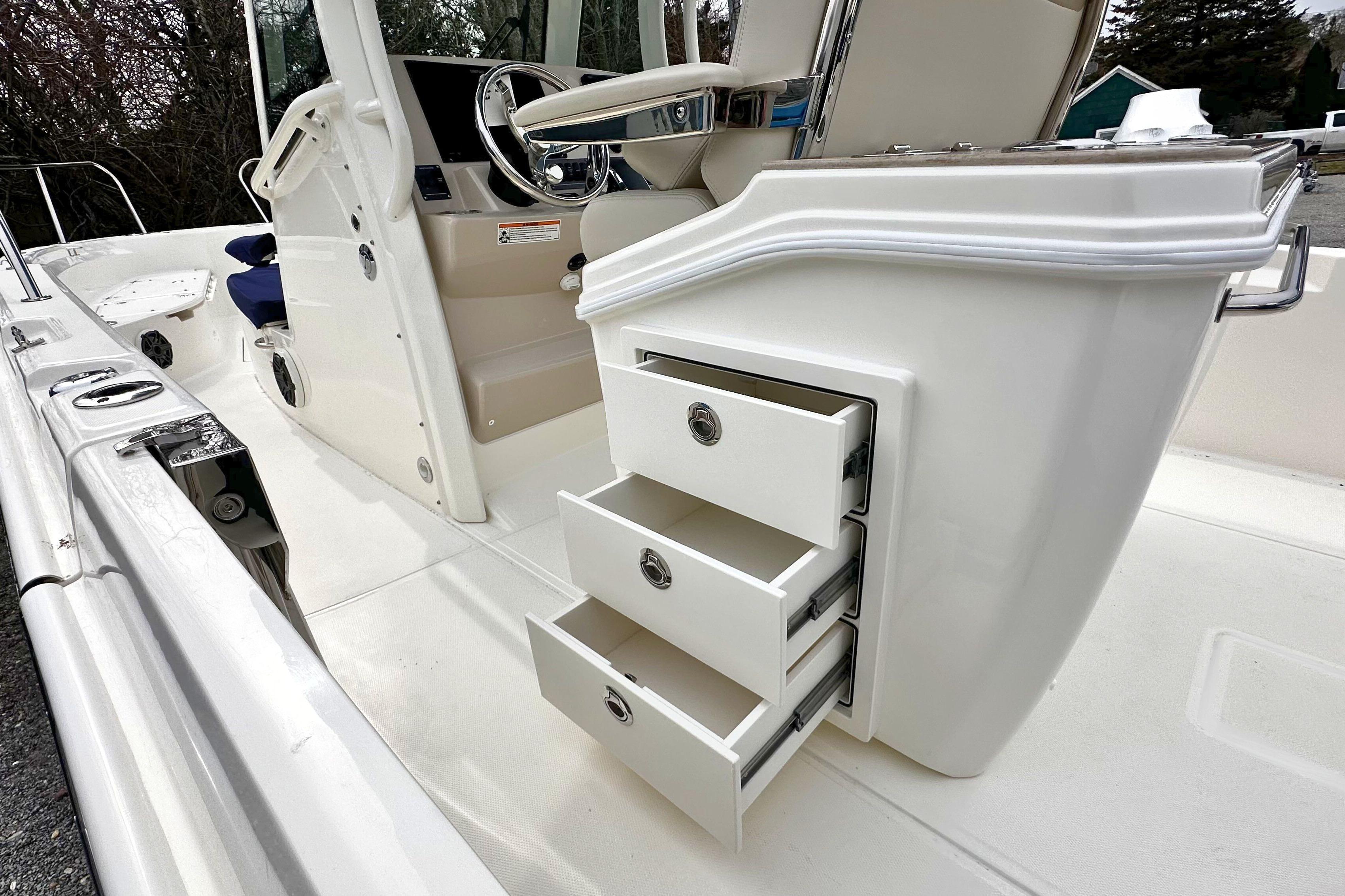 2026 Boston Whaler 280 Dauntless boat interior with open storage drawers and steering console.