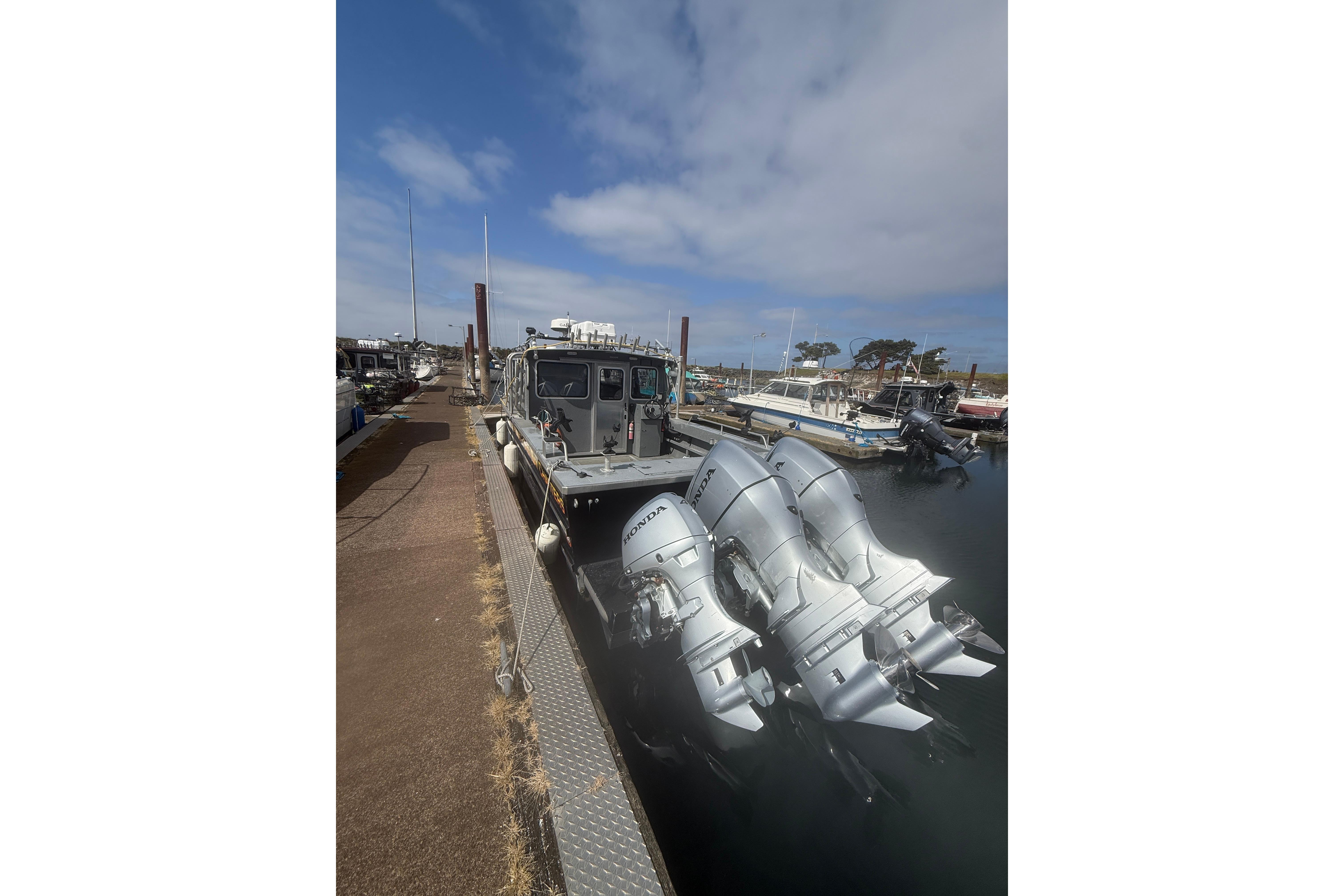 2016 North River 29 Offshore boat docked with multiple Honda outboard engines.