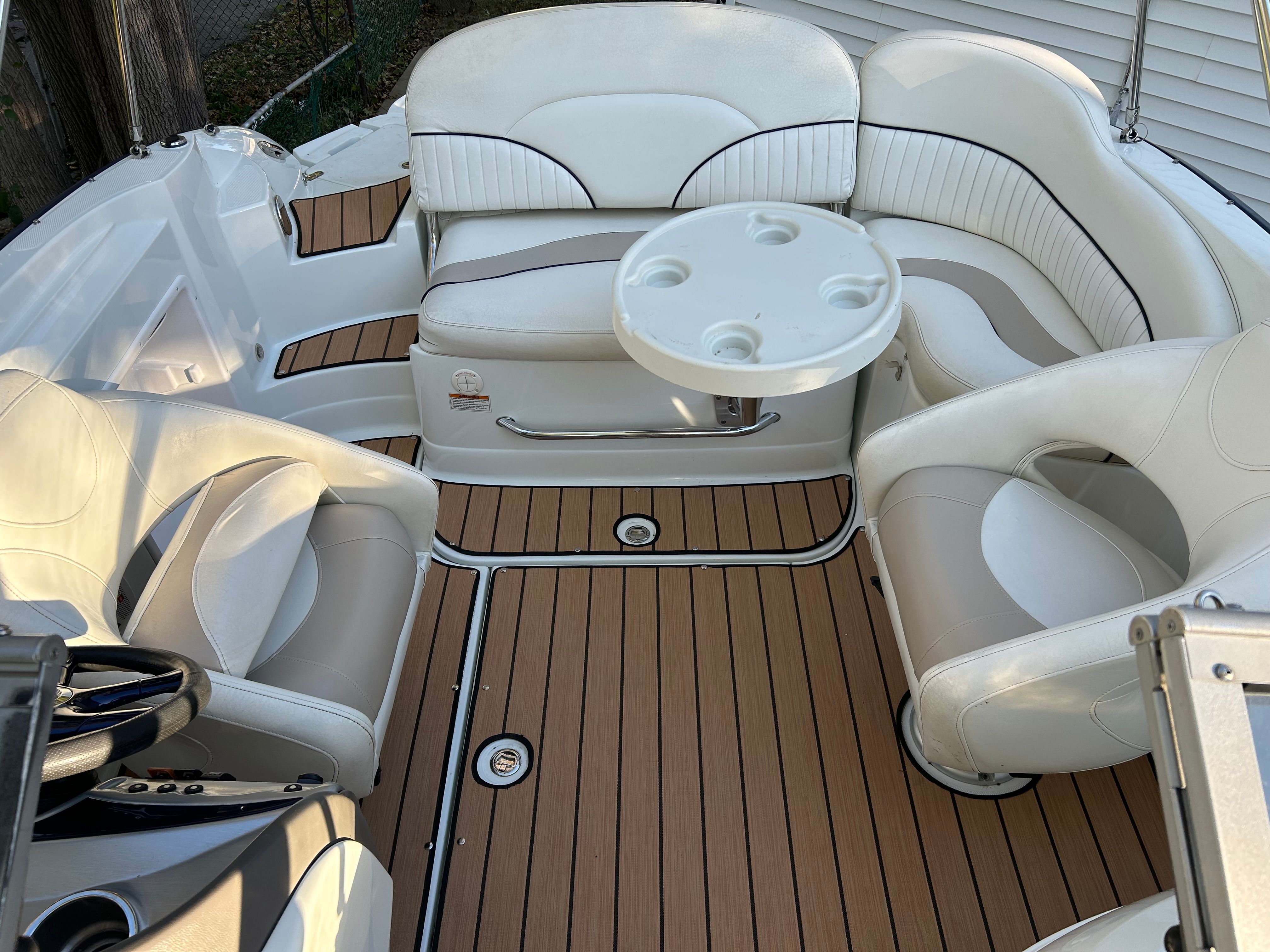 The image shows the cockpit of a 2008 Azure AZ220 boat with white upholstered seats and a table.