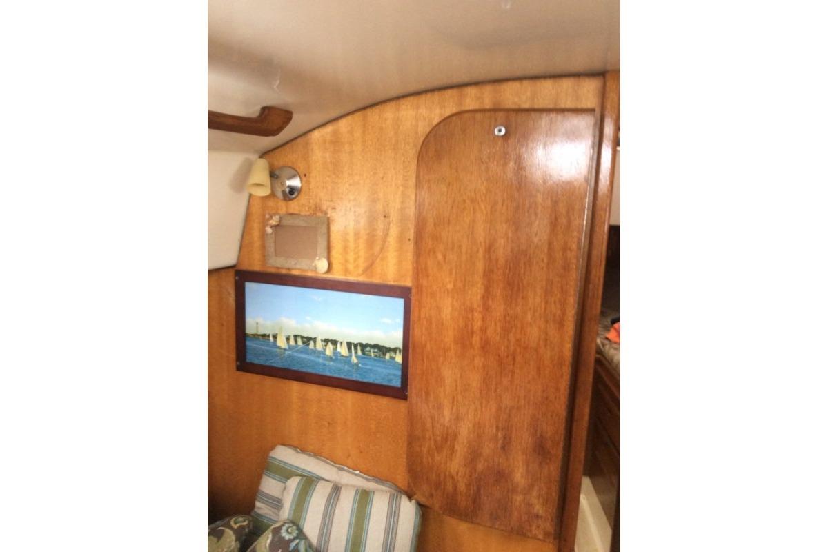 Interior of 1980 Sloop 27.7 Bristol sailboat with wooden paneling and nautical decor.