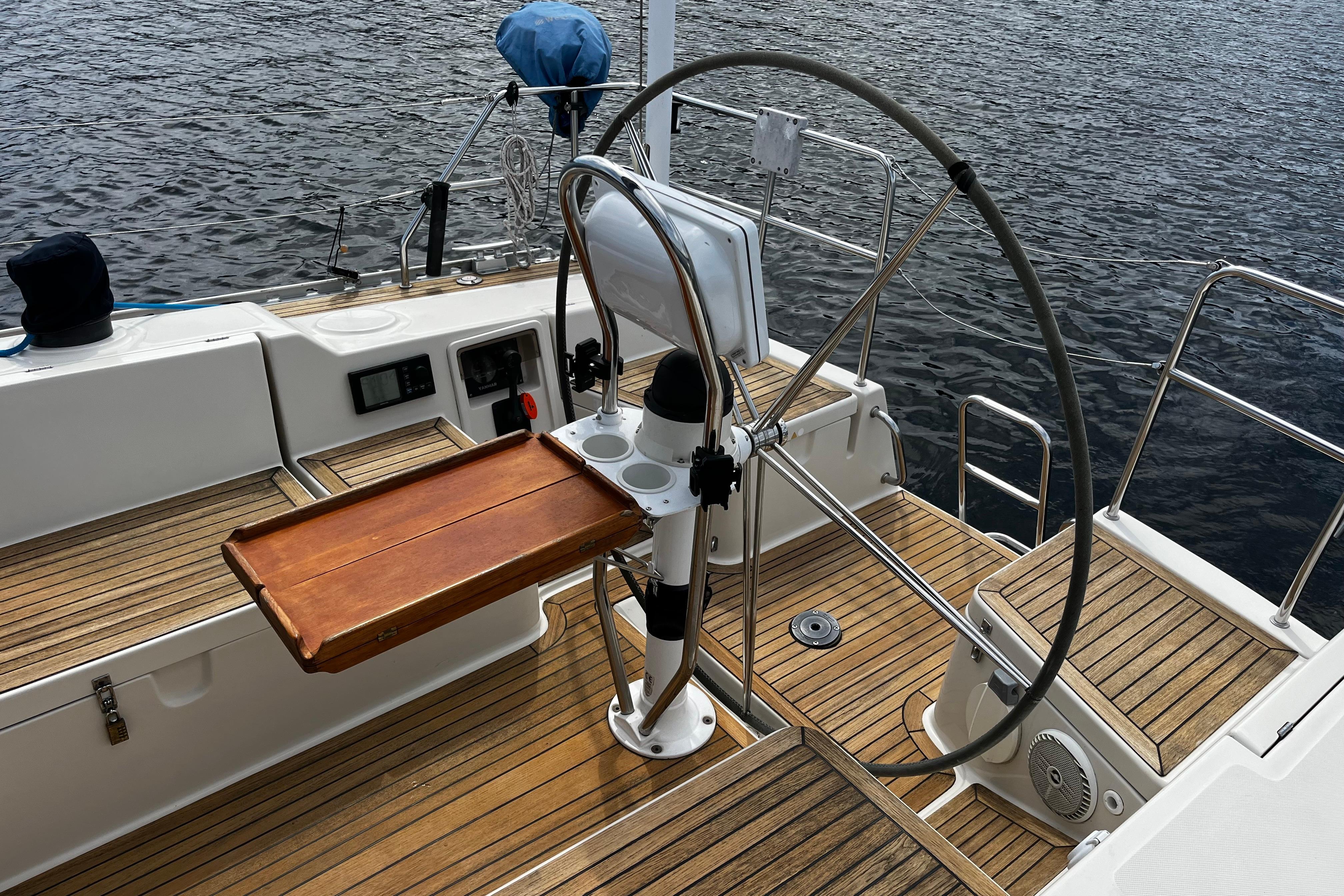 Cockpit of 2004 Hanse 411 sailboat with wooden deck and steering wheel.