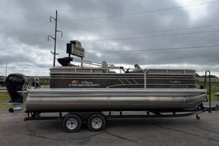2022 SUNTRACKER Party Barge 22 pontoon boat on trailer, parked outdoors.