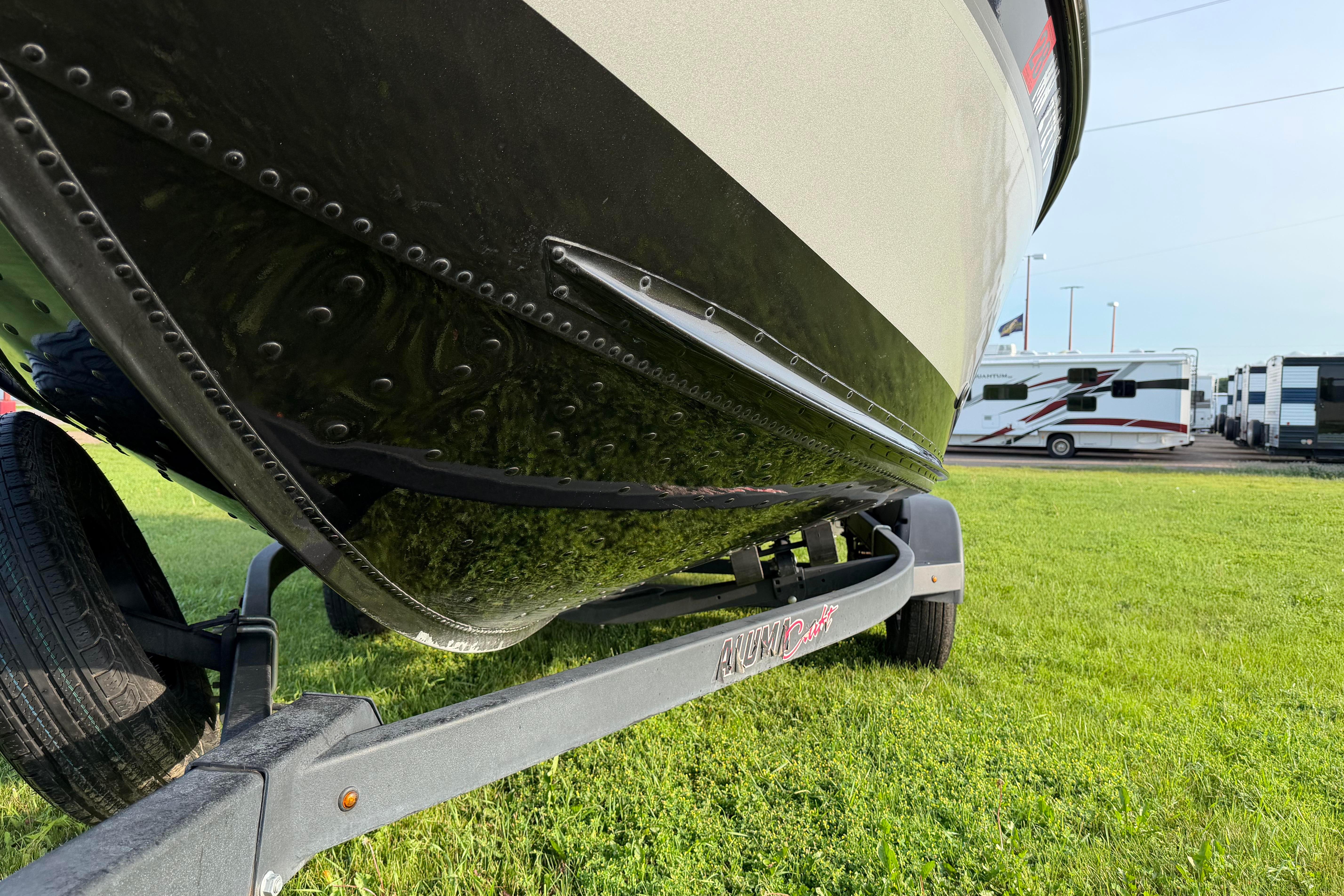 2019 Alumacraft Trophy 205 boat on trailer, parked on grass.