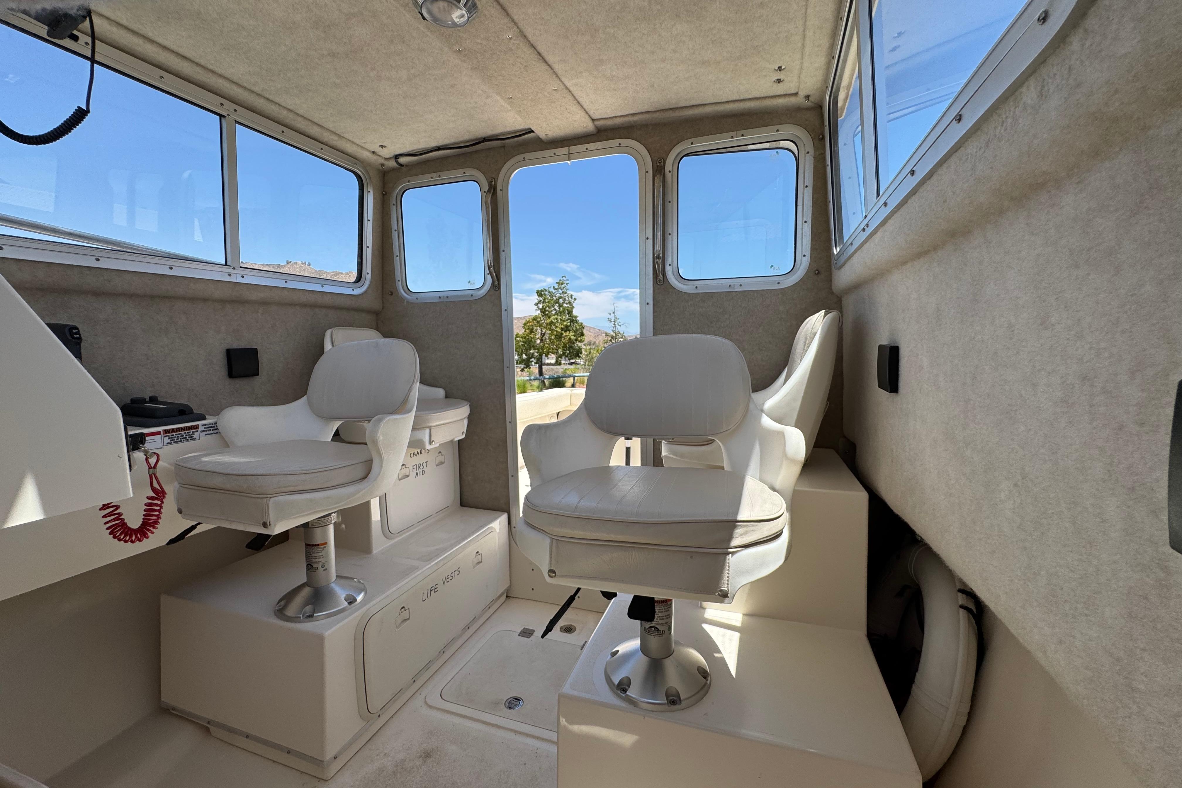 Interior of a 2017 Defiance Admiral 220 EX boat with seating and windows.