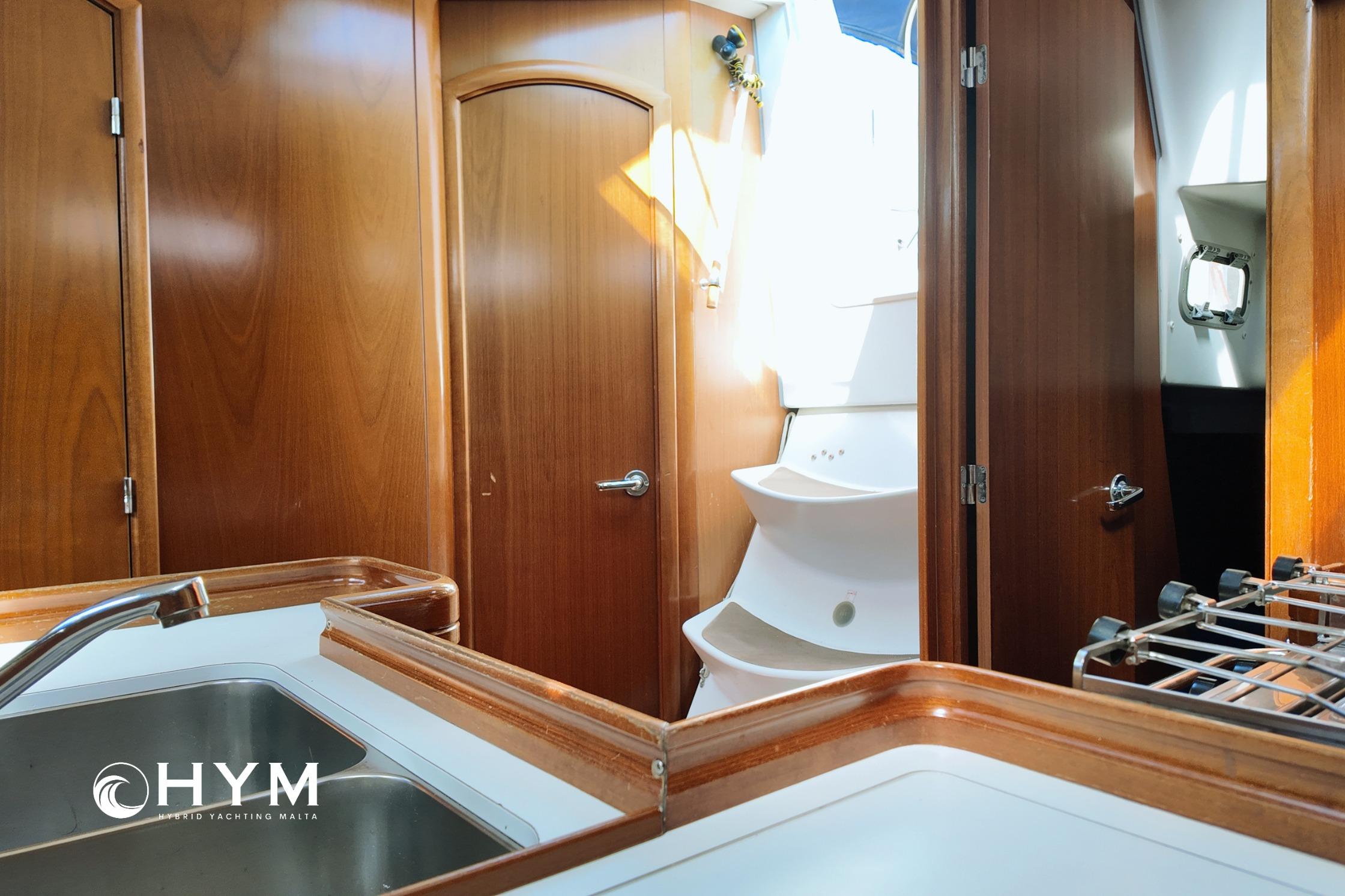 Interior of 2005 Beneteau Oceanis Clipper 373 yacht with wooden cabinetry and sink.