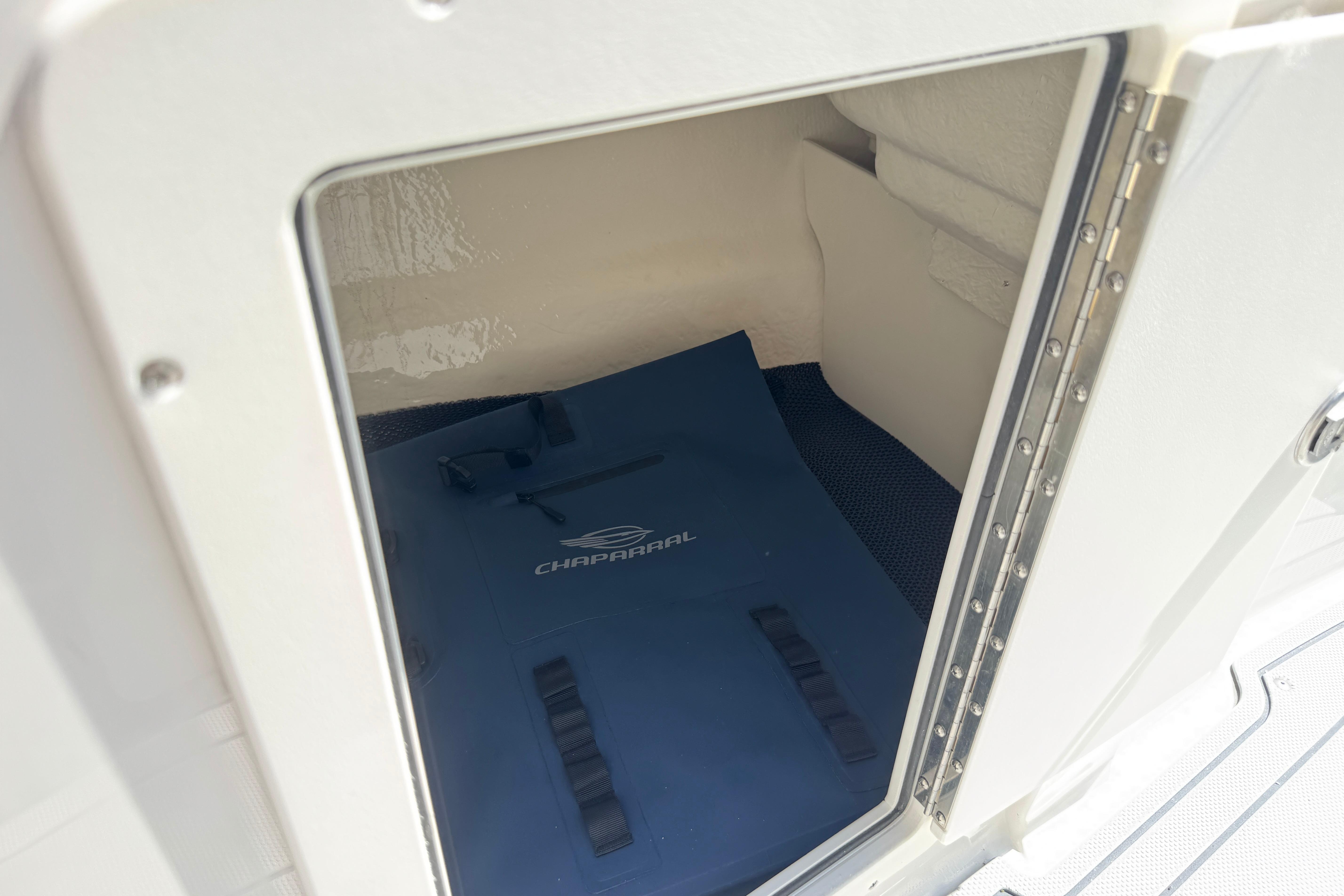 Storage compartment in 2026 Chaparral 21 SSi boat with blue Chaparral mat.
