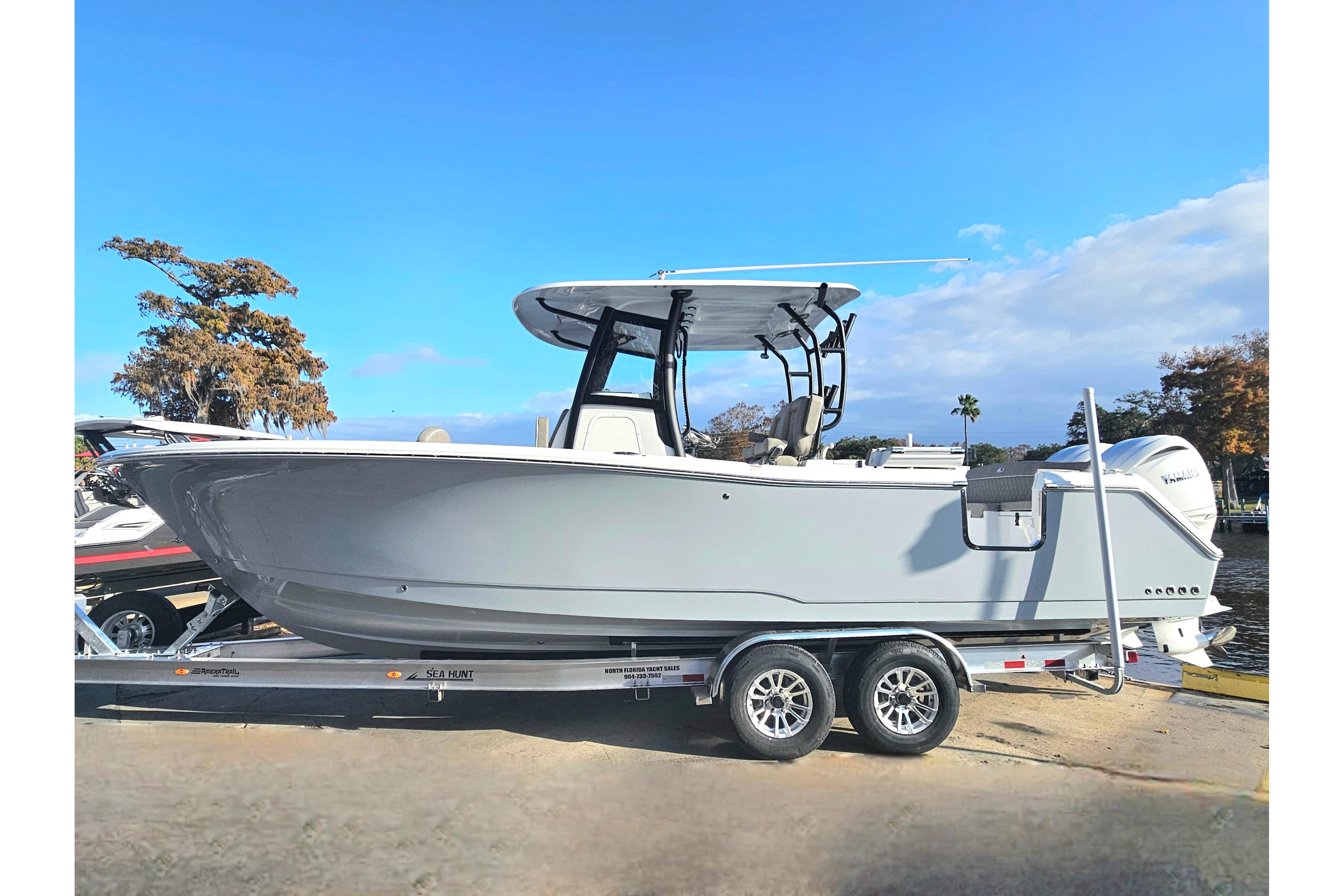 2026 Sea Hunt Ultra 285 SE boat on trailer, side view, clear sky background.