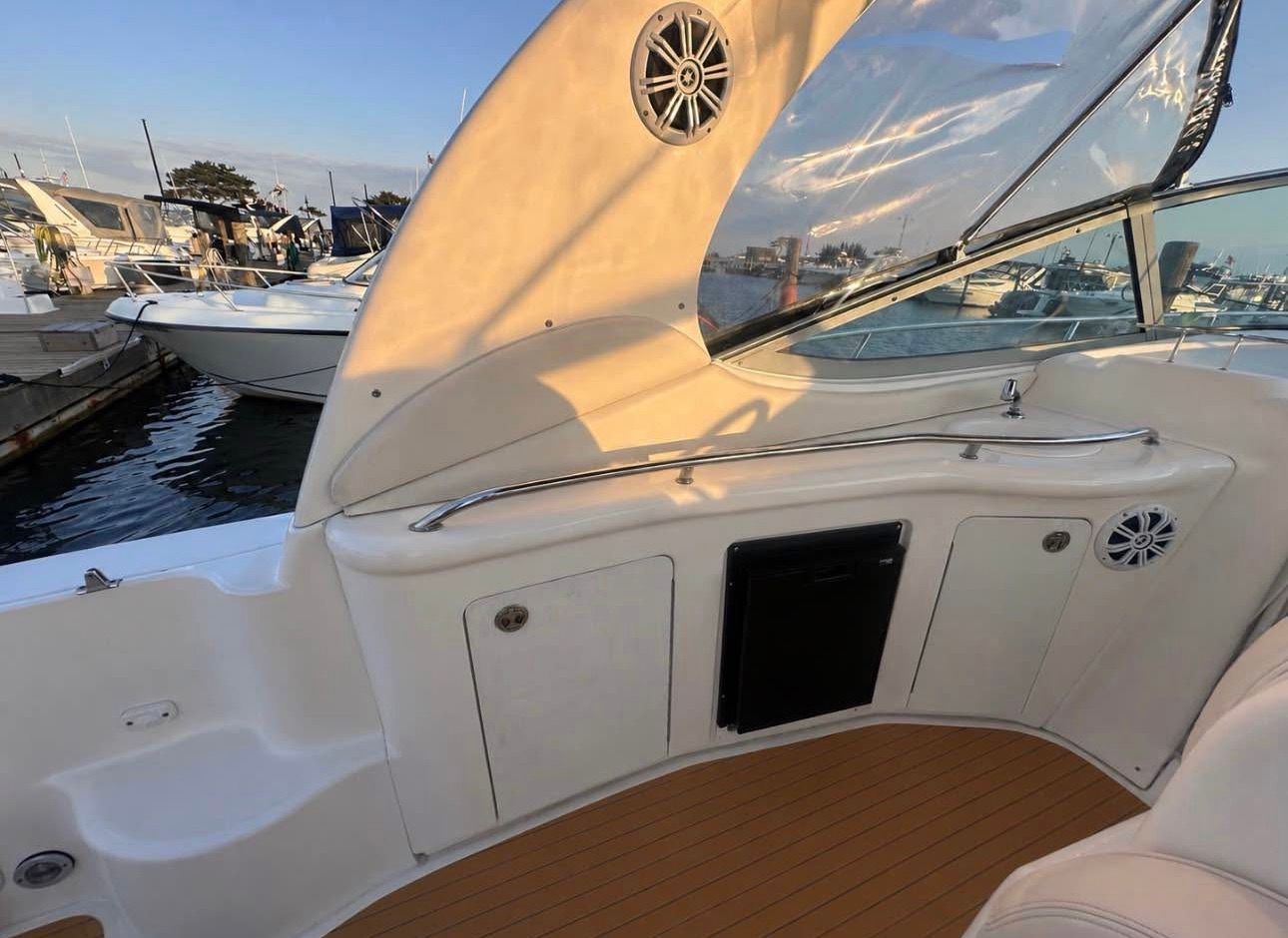 The image shows the cockpit of a 2002 Sea Ray 300 Sundancer. It is docked at a marina.