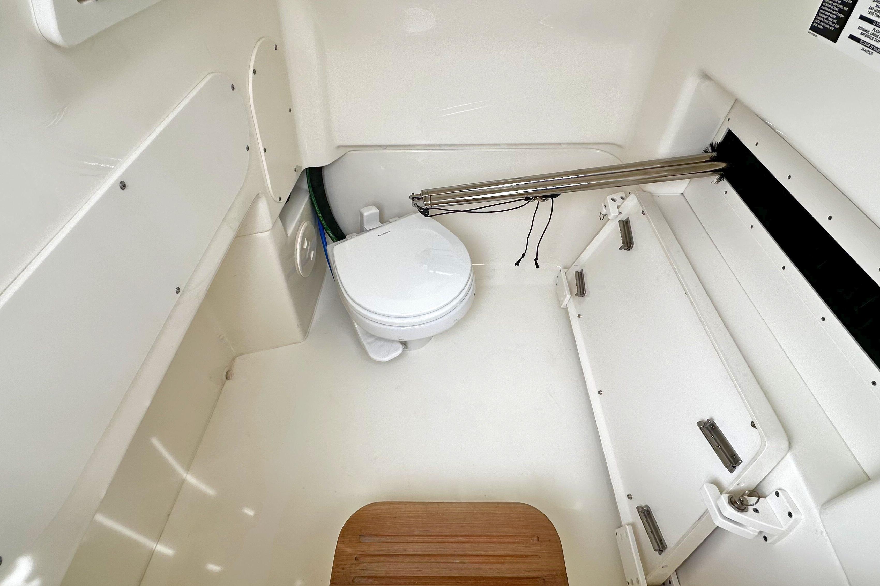 Interior of 2026 Boston Whaler 280 Dauntless boat, featuring a compact marine toilet.
