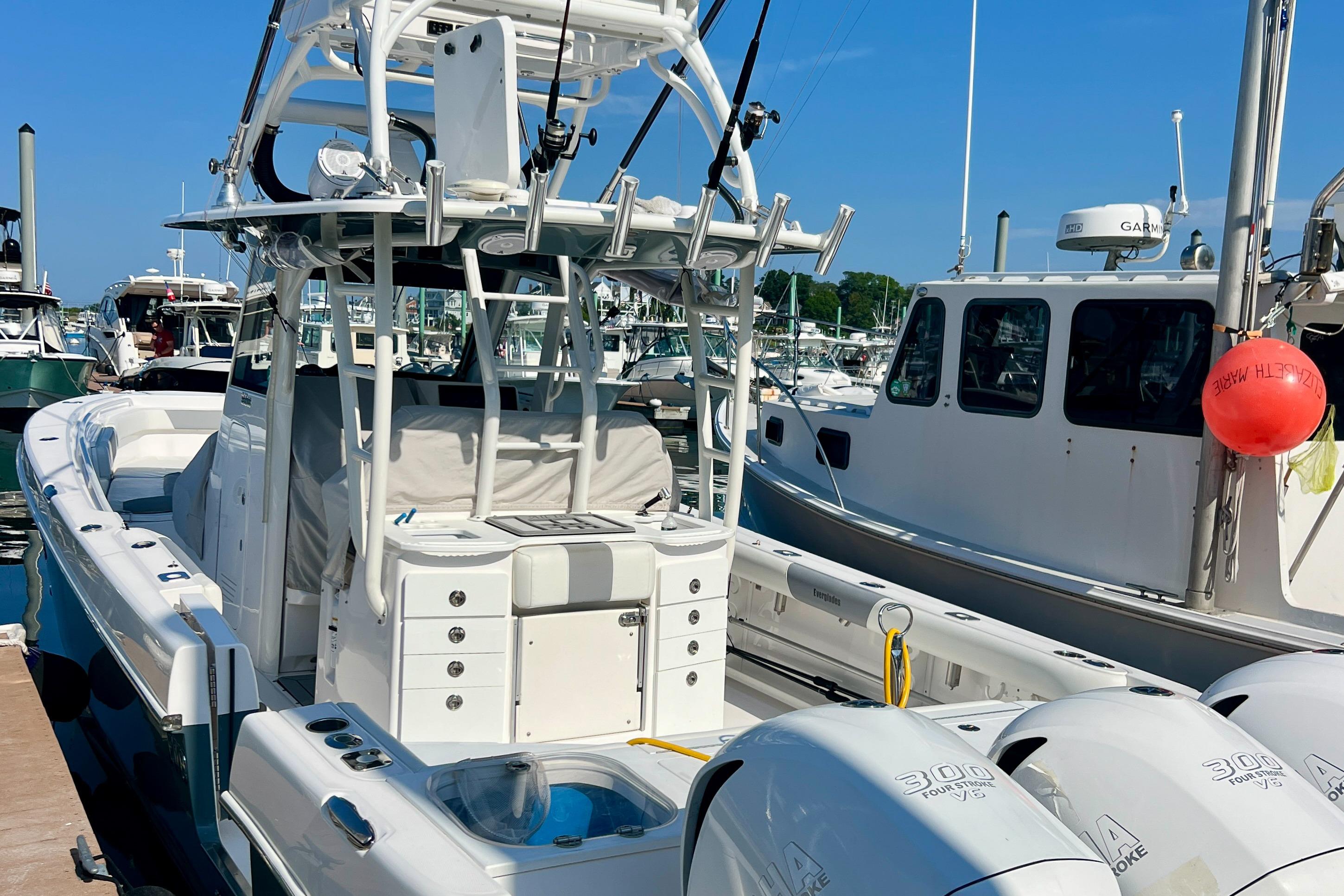 2017 Everglades 355 Center Console boat docked at marina, featuring triple outboard engines.