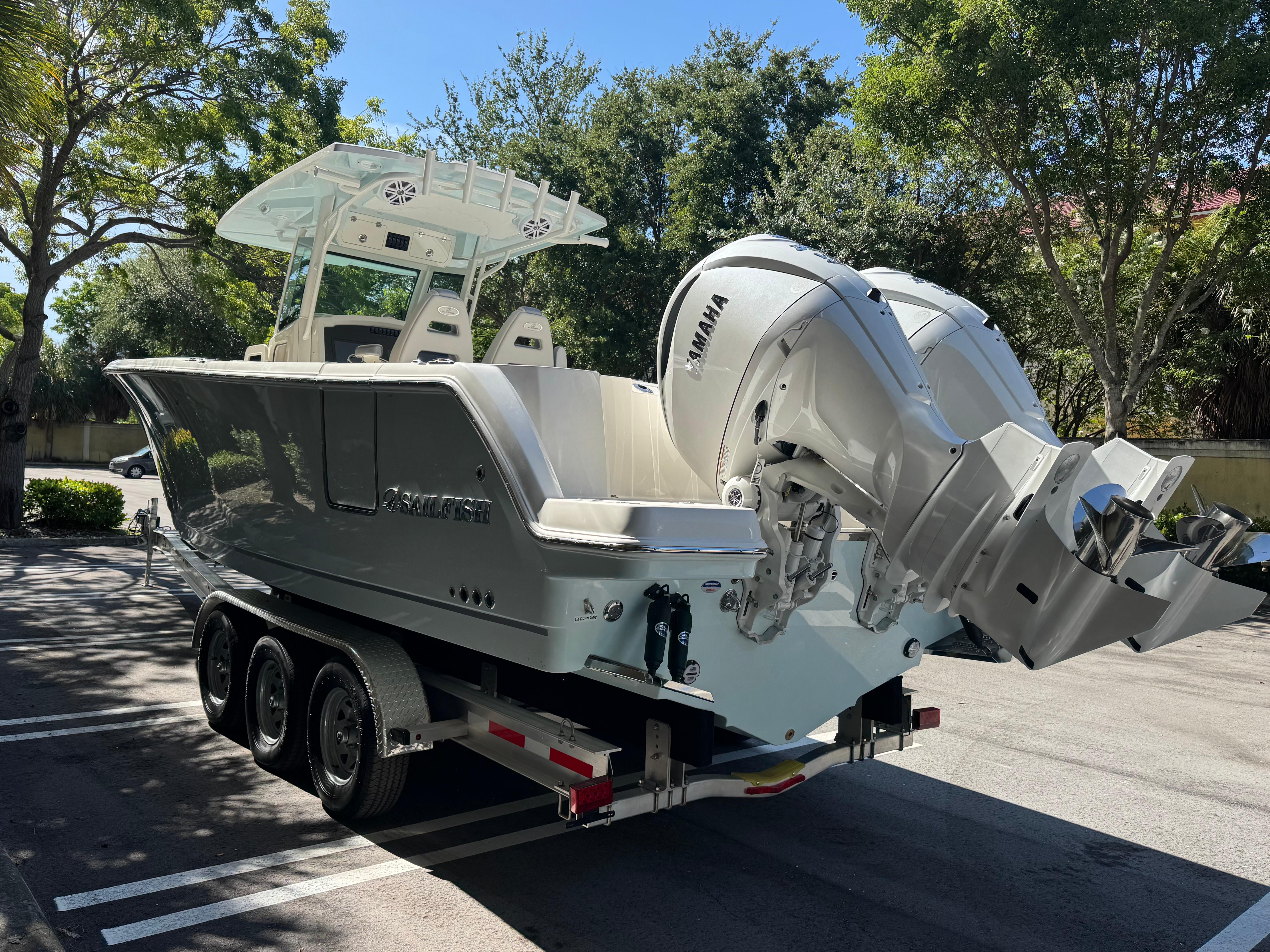 2026 Sailfish 312 CC boat on trailer with dual Yamaha engines, parked outdoors.