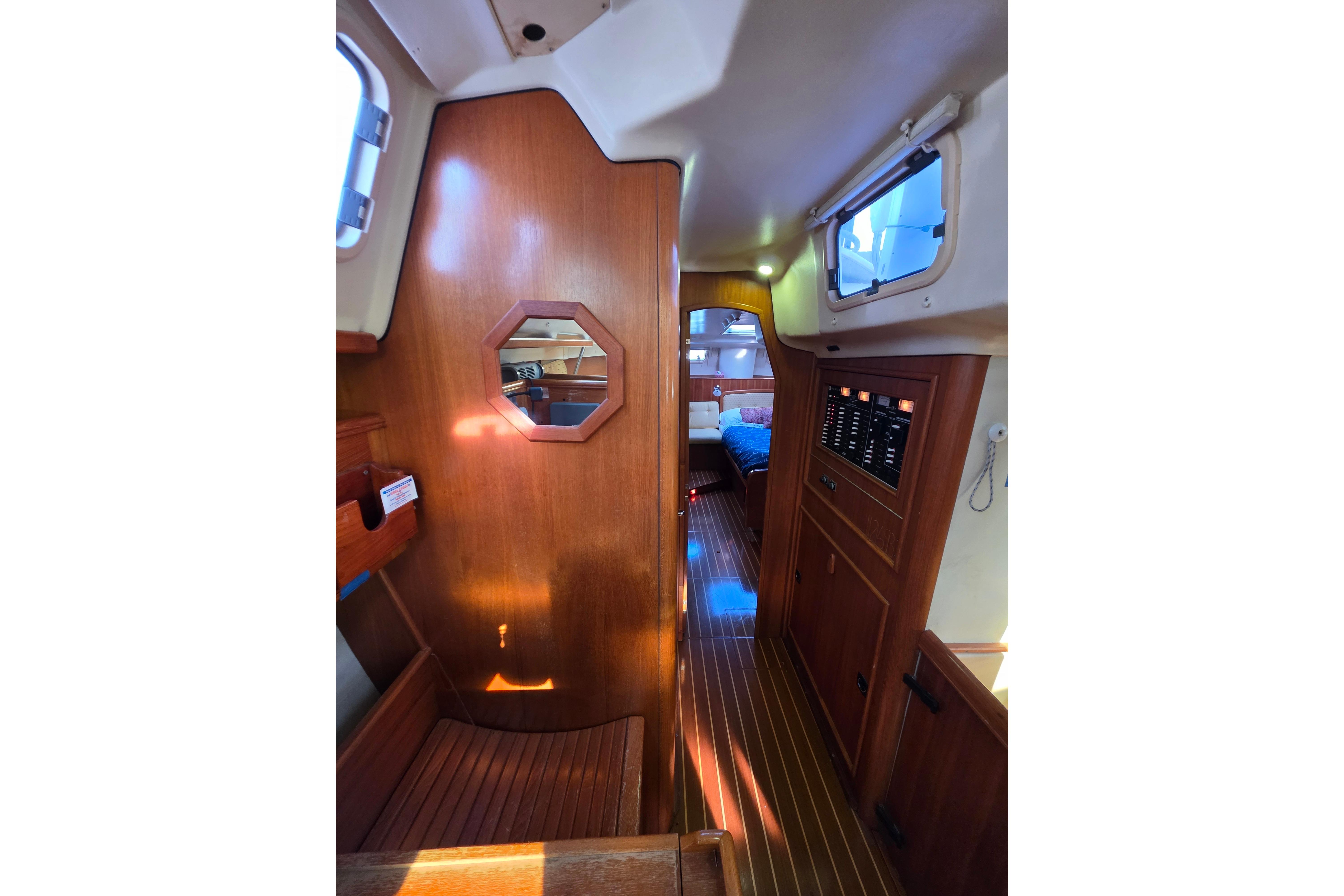 Interior of 2002 Hunter Passage 450 yacht with wood paneling and cozy cabin.