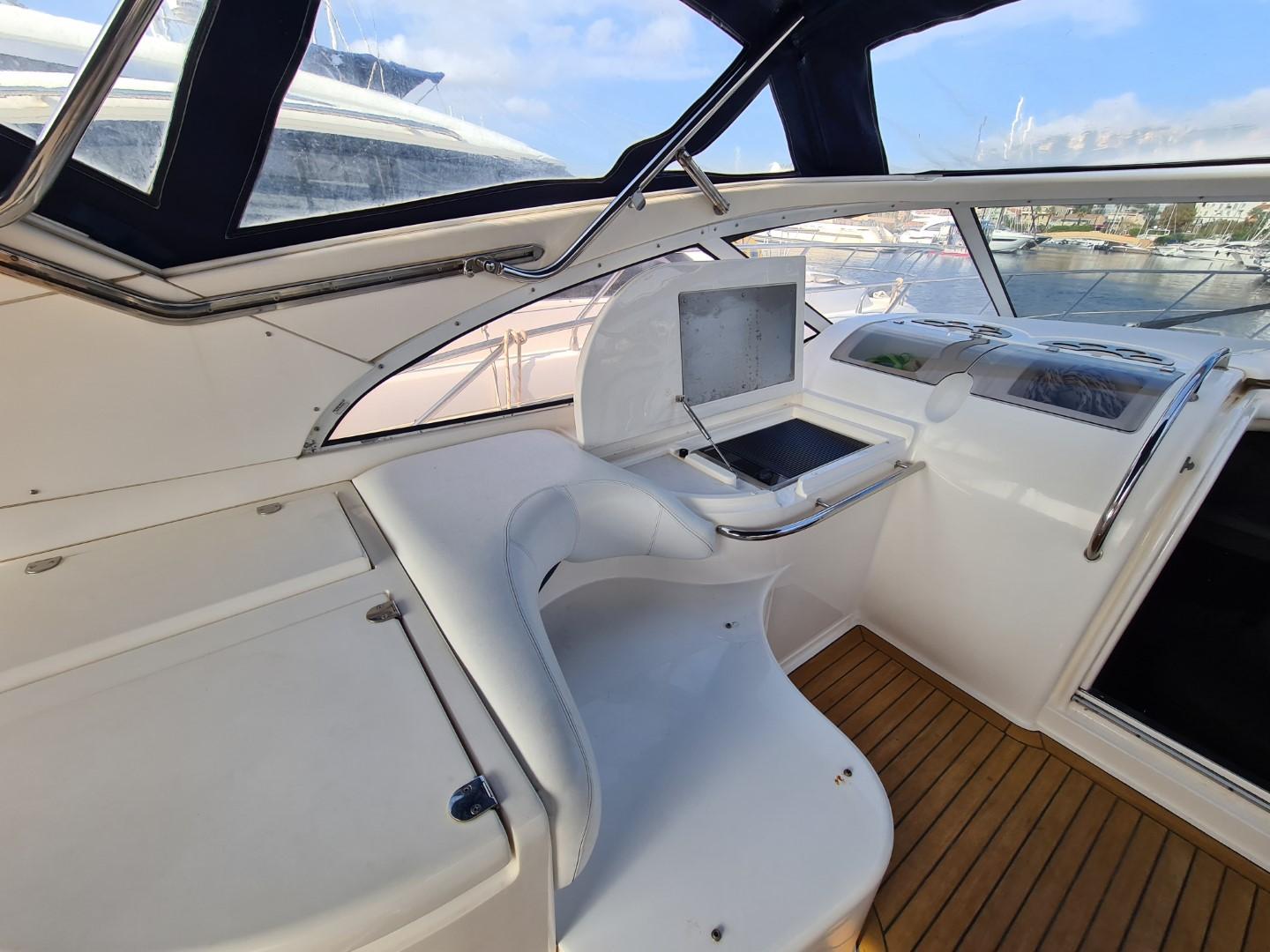 2004 Fairline Targa 43 yacht cockpit with modern navigation equipment and wooden flooring.