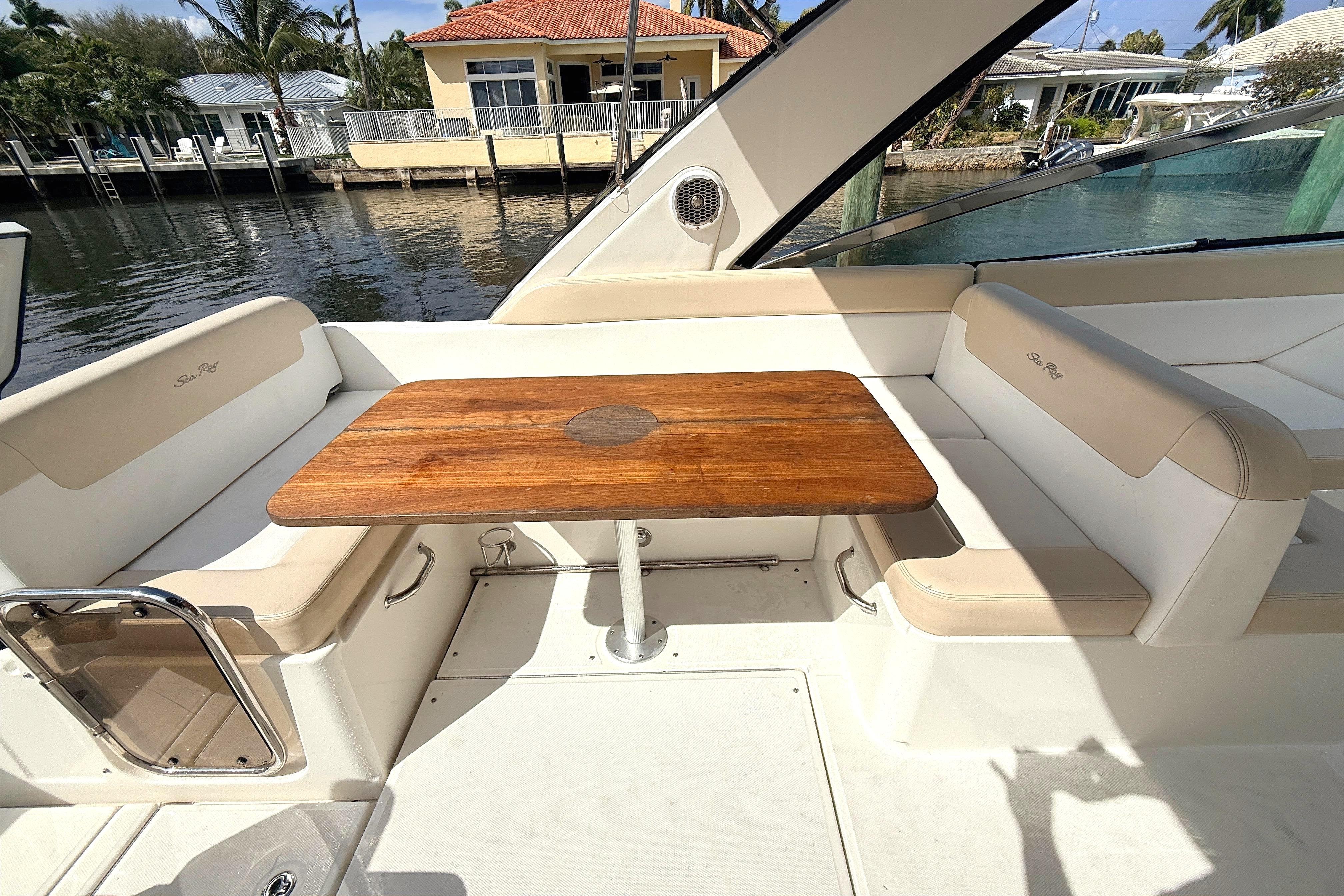 2013 Sea Ray 370 Venture boat interior with wooden table and cushioned seating.
