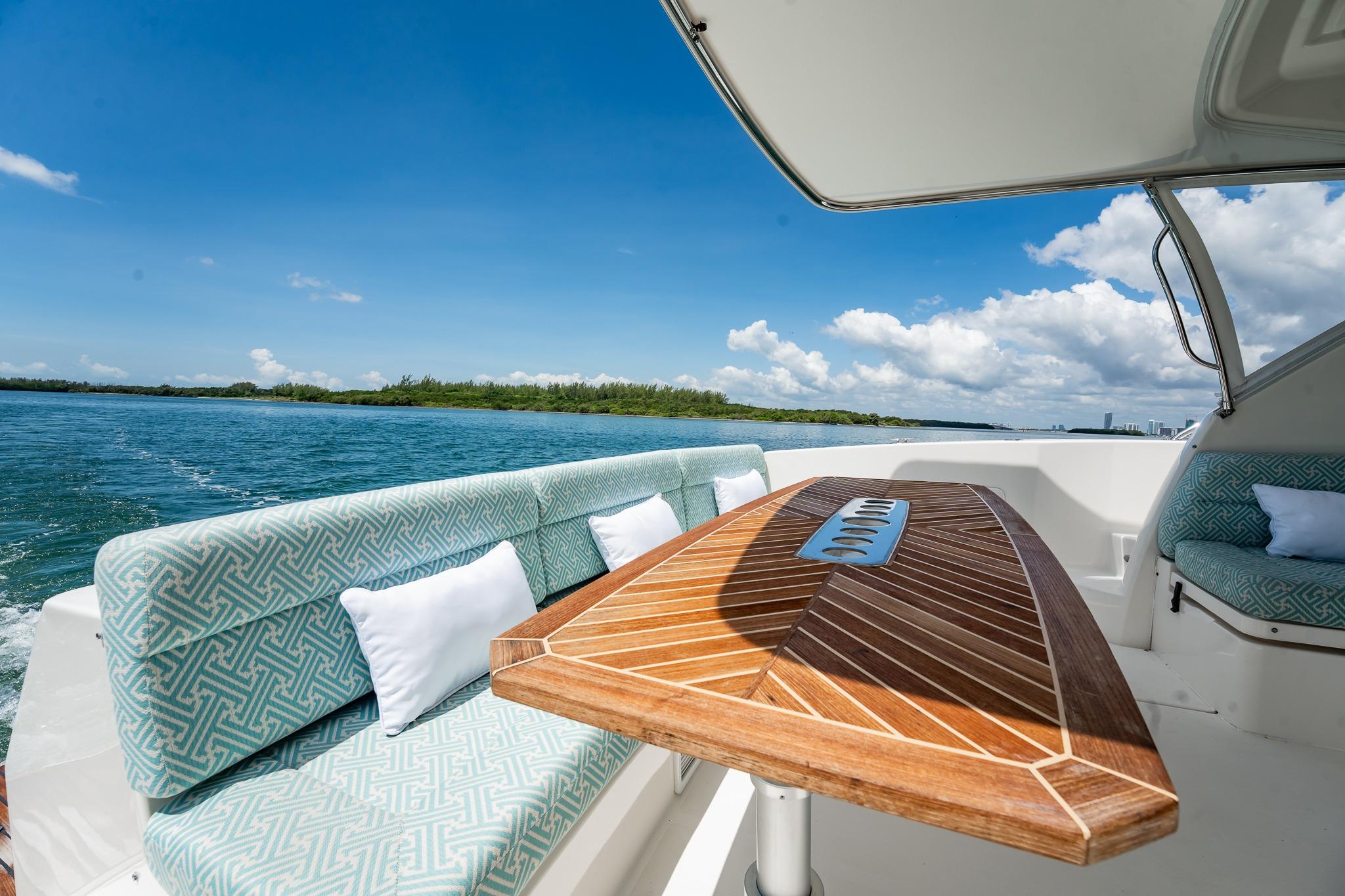 Luxurious 2016 Riviera 5000 Sport Yacht interior with elegant seating and wooden table.
