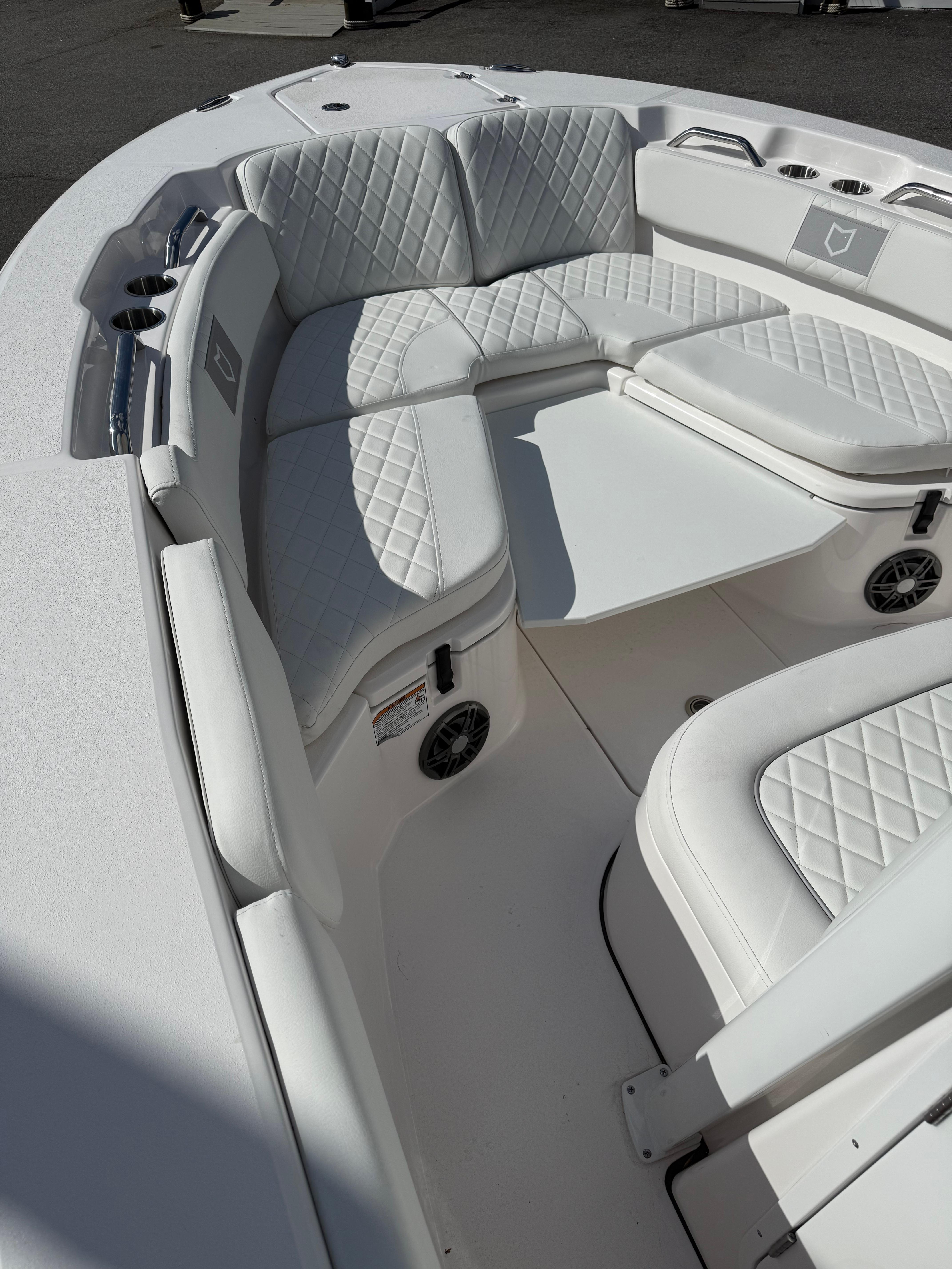 2026 Sea Fox 228 Commander boat interior with white quilted seating and cup holders.