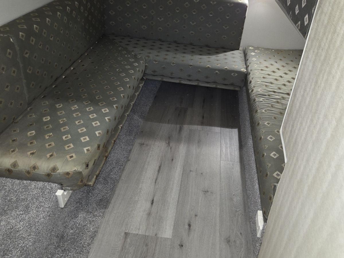 The boat's interior features cushioned benches with patterned upholstery and a wooden floor.