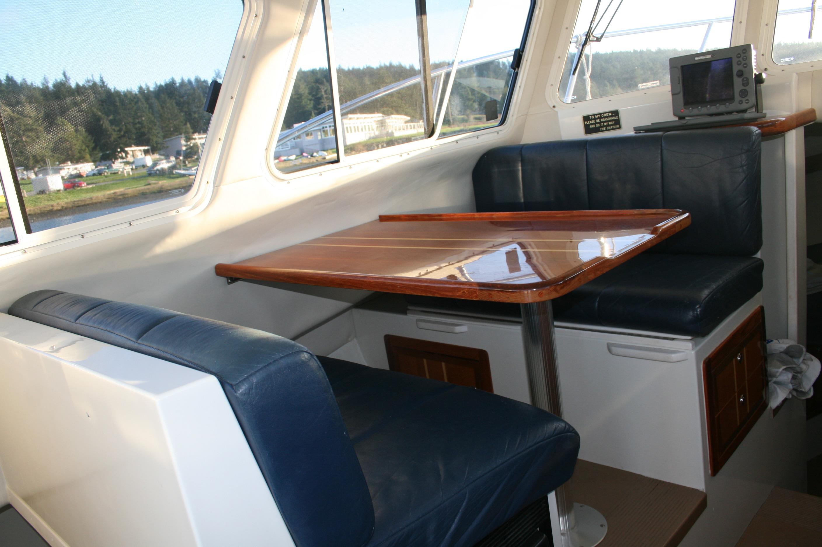Interior of a 2005 Ocean Sport 30' boat with seating and a wooden table.