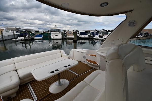 2003 Sea Ray 460 Sundancer yacht interior with marina view, featuring white seating and table.