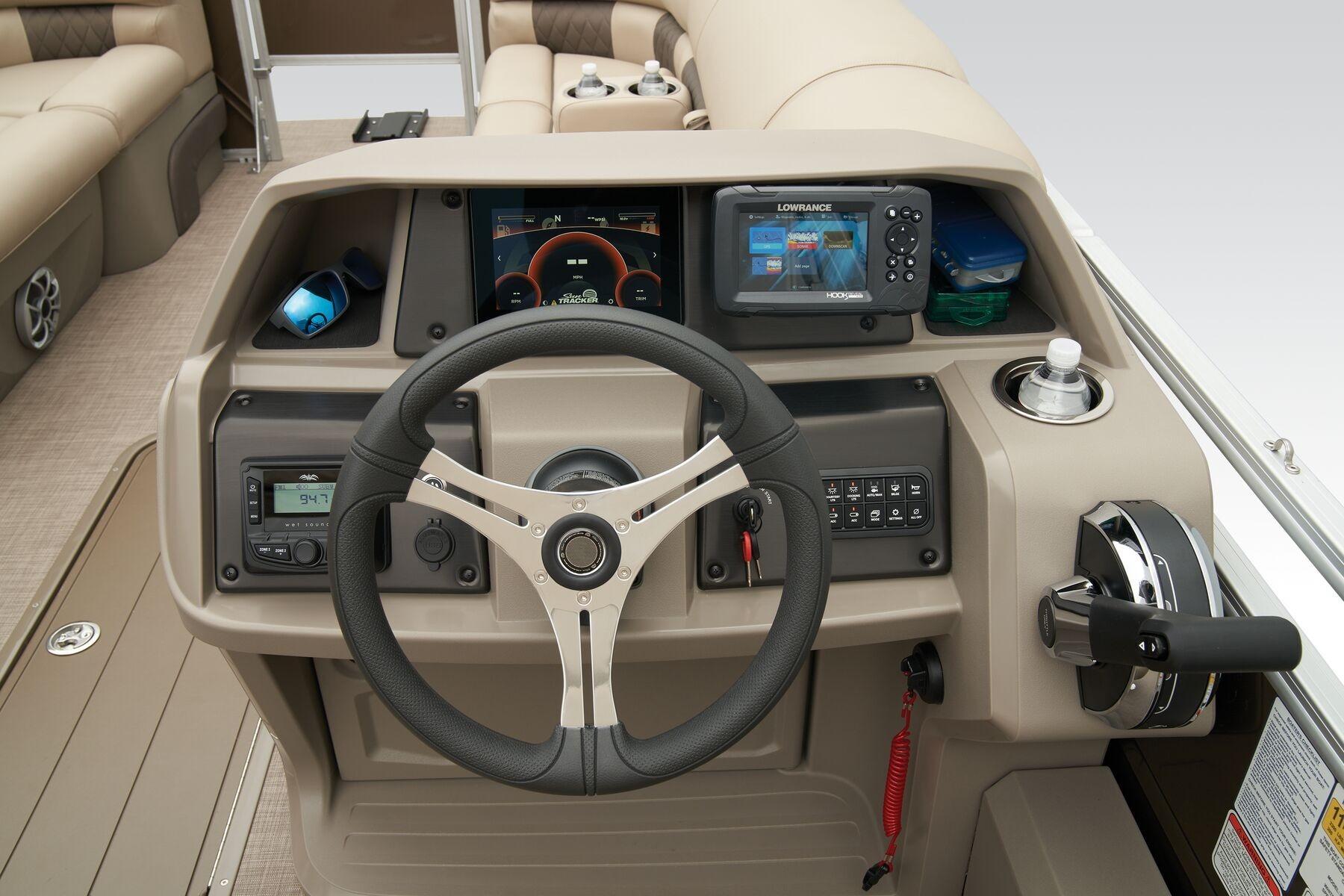 2023 Sun Tracker SportFish 22 XP3 helm with steering wheel, controls, and navigation display.