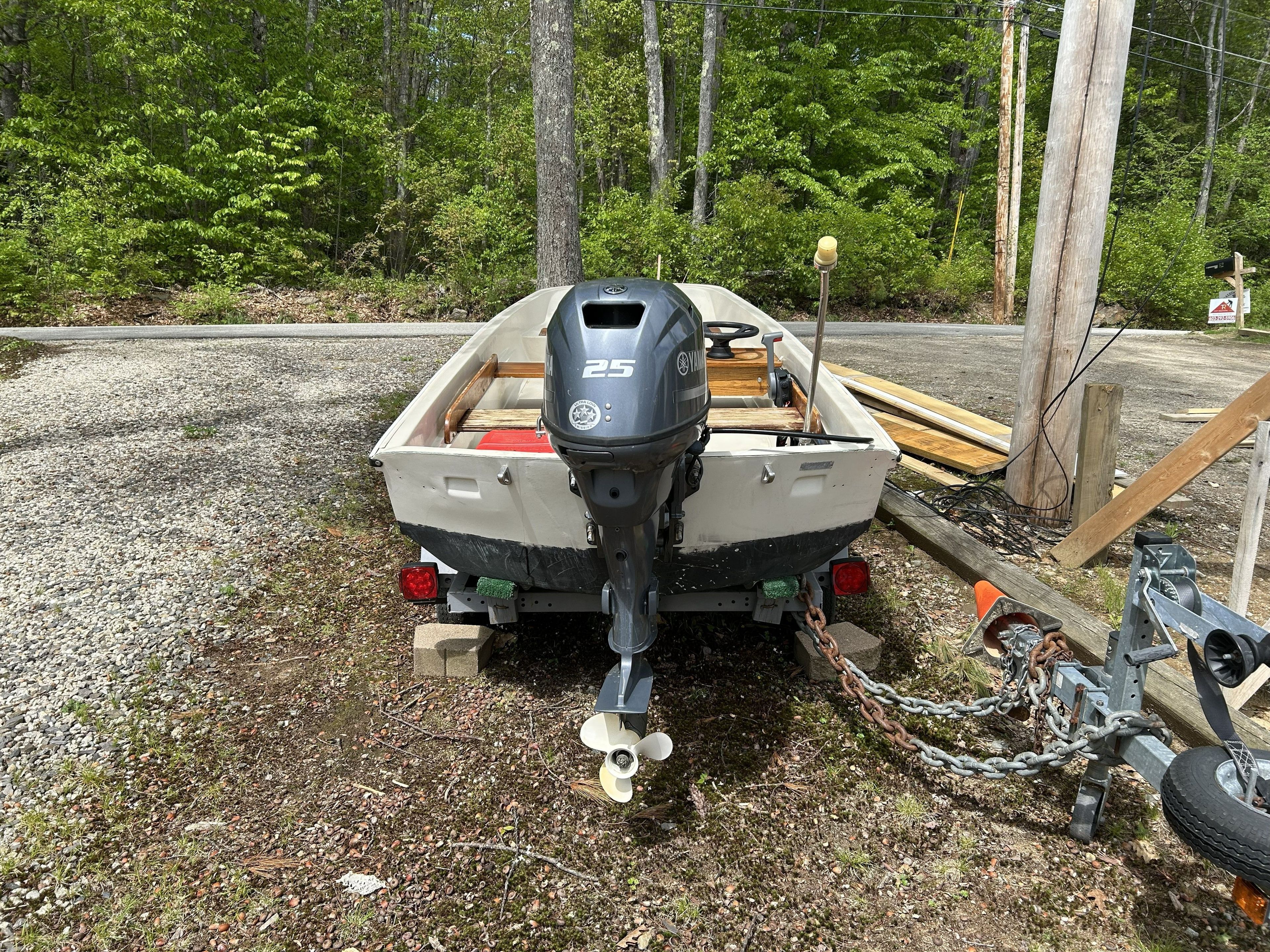 1975 Boston Whaler 13 ft boat with outboard motor parked outdoors.