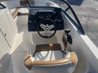 2022 Bayliner VR6 boat cockpit with steering wheel and seating, featuring modern design elements.