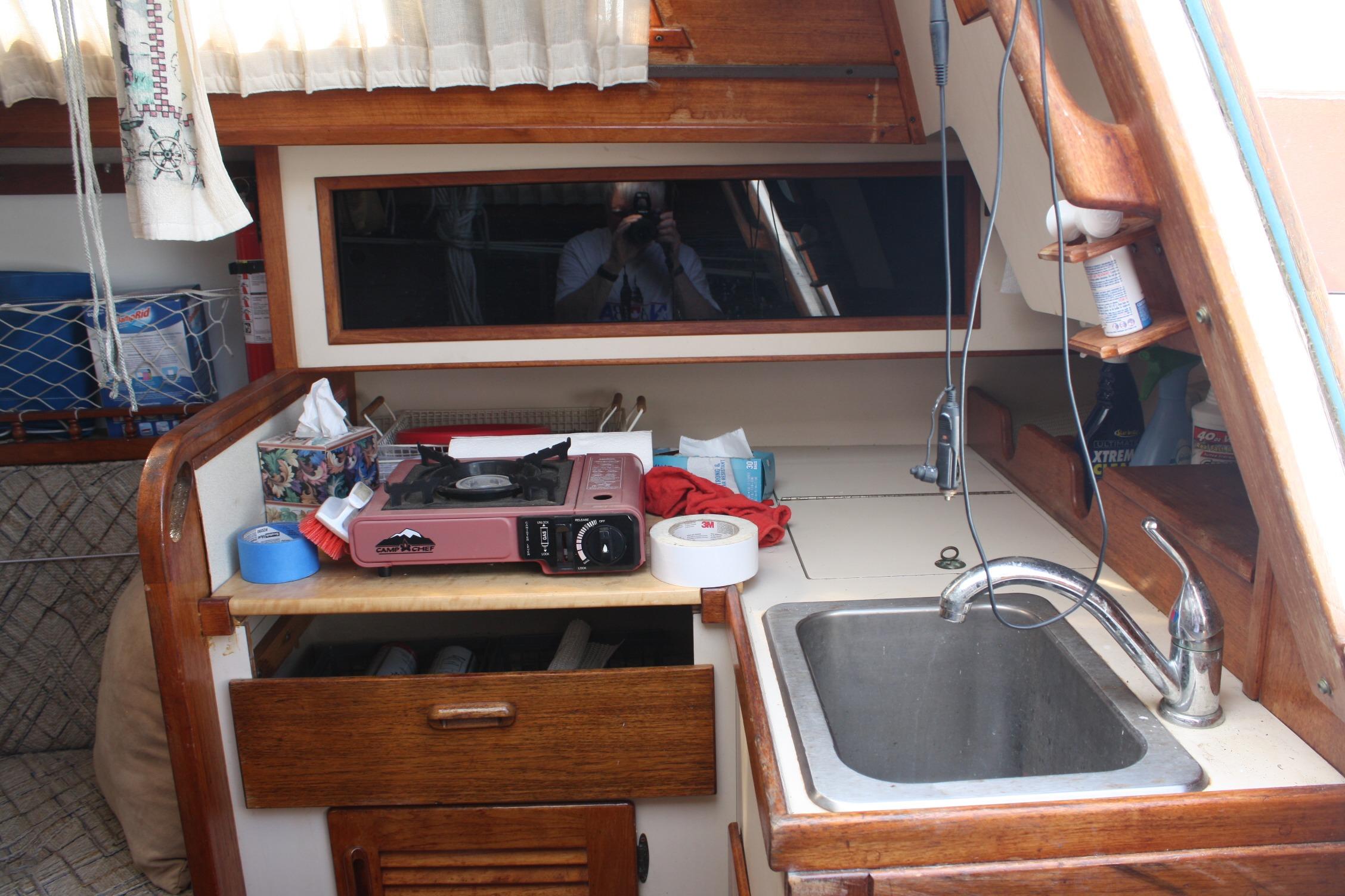 Compact kitchen area in a 1981 S2 9.2A sailboat with stove and sink.