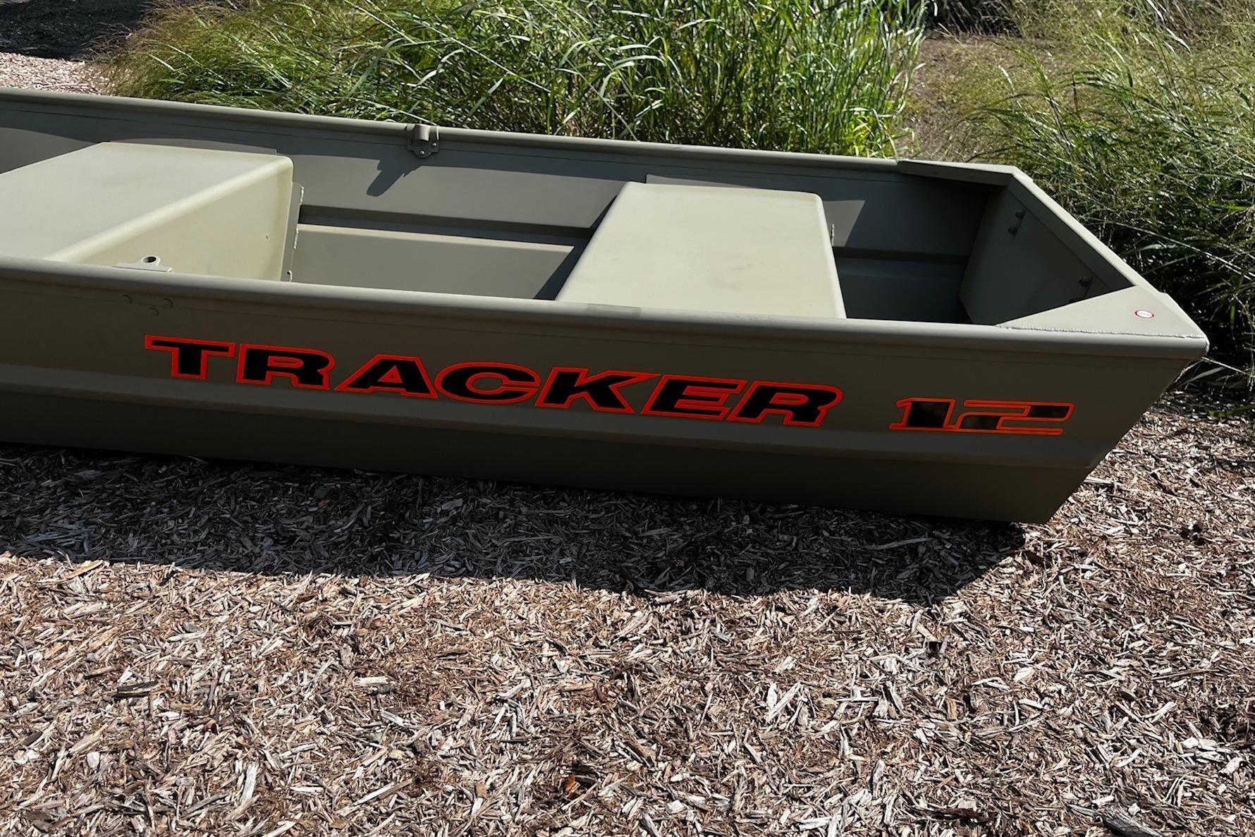 2026 Tracker Grizzly 12 Jon boat on wood chips, surrounded by grass.