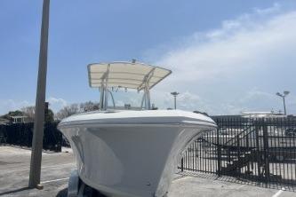 2023 Sailfish 242 CC boat with canopy, parked outdoors under a clear sky.