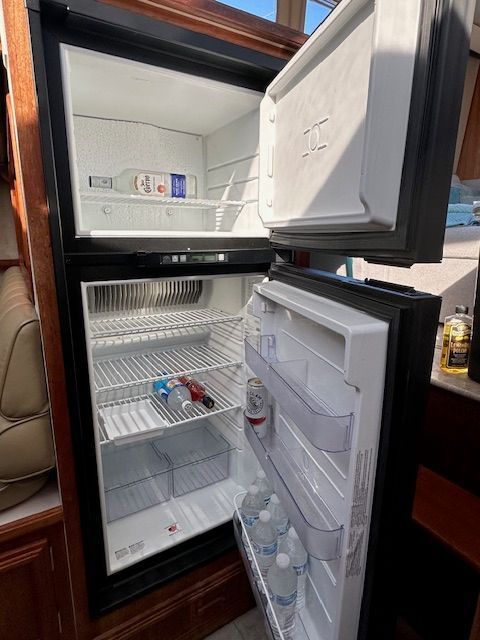 Open fridge on Carver 3807 yacht, stocked with beverages.