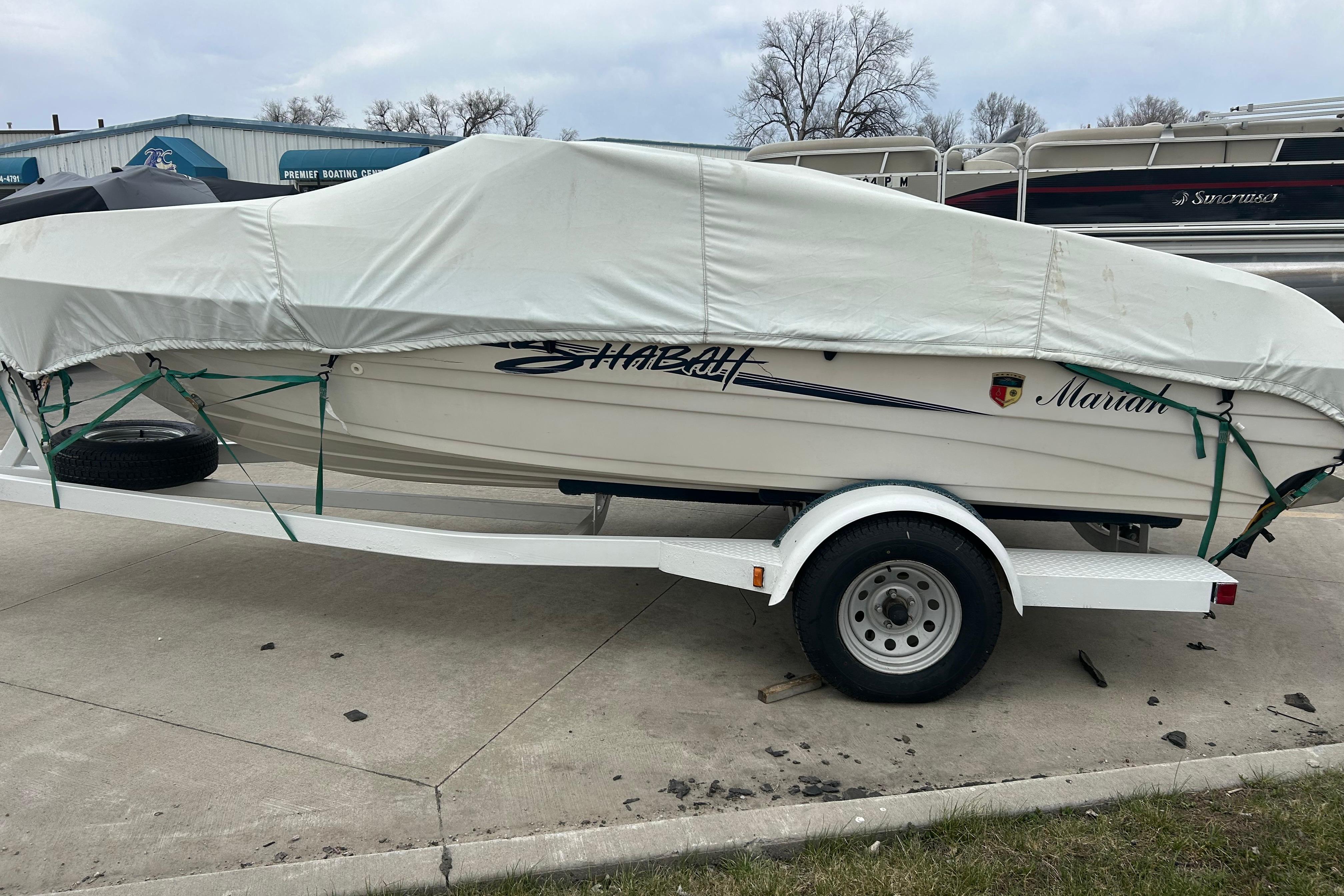 Covered 1996 Mariah 180 Shabah boat on trailer, parked outdoors.