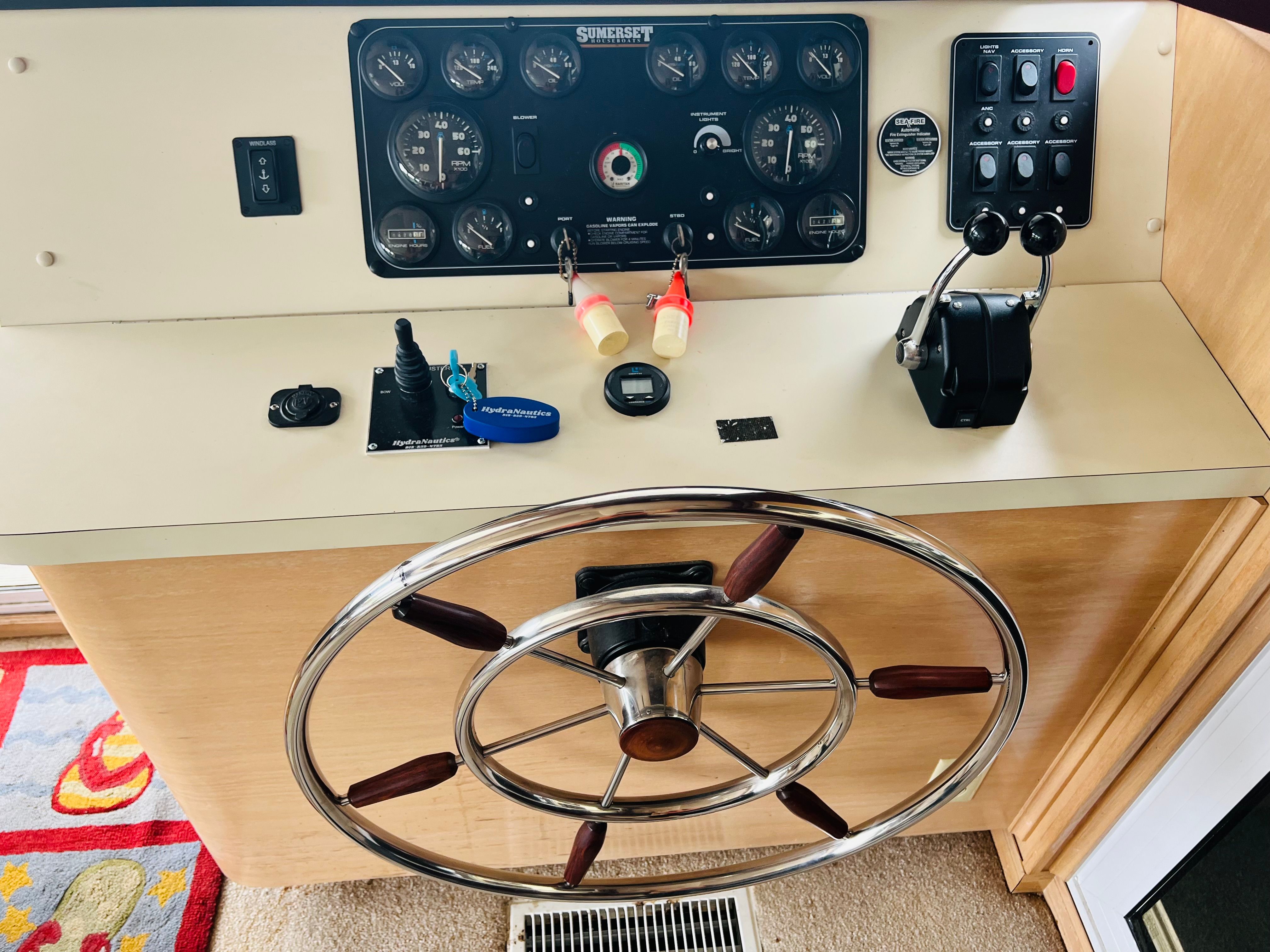 1998 Sumerset houseboat helm with steering wheel, control panel, and throttle levers.