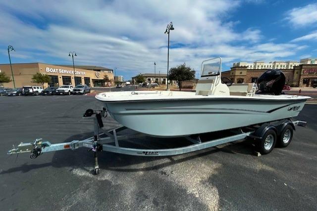 2026 Mako Pro Skiff 19 CC boat on trailer in parking lot near service center.