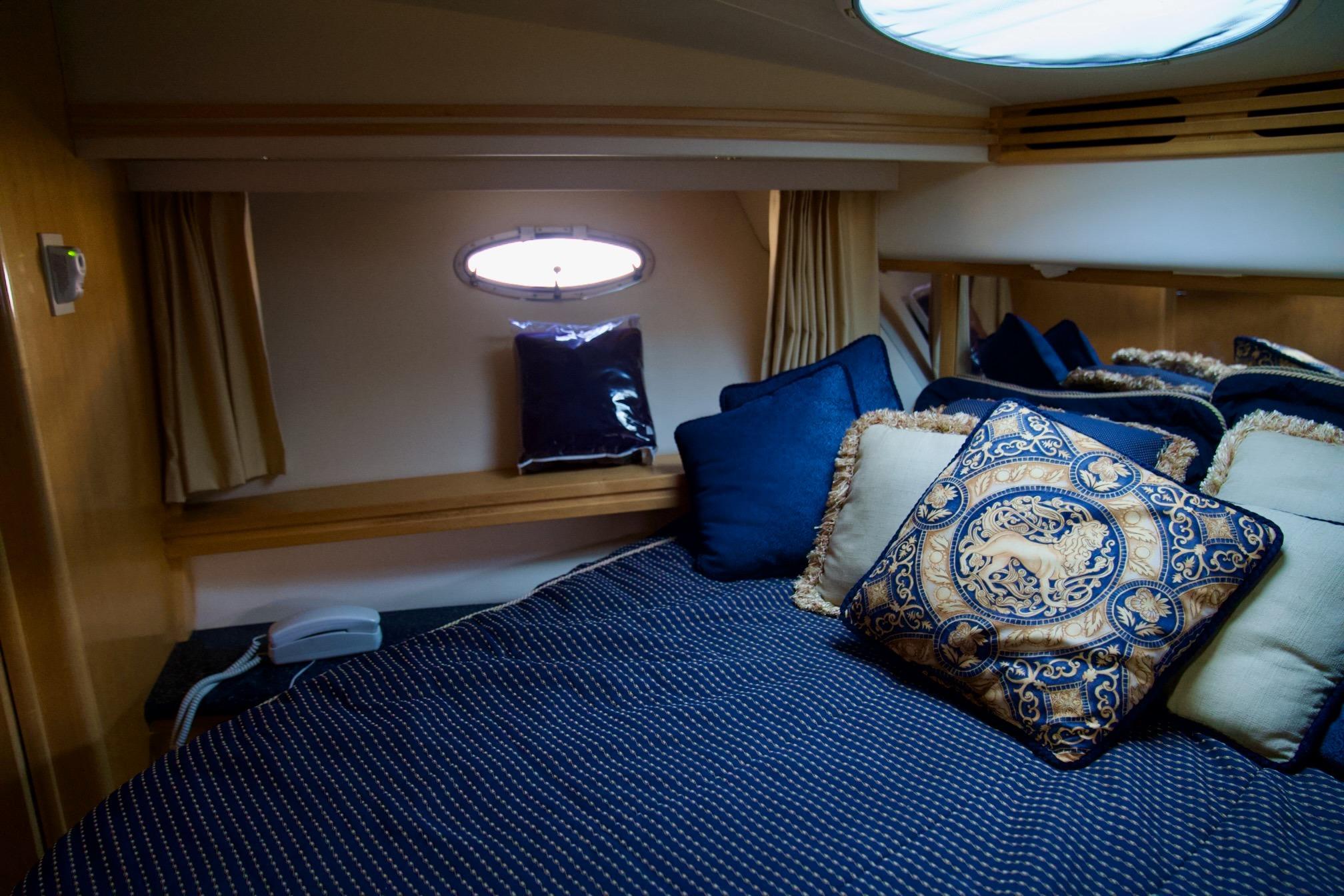 Luxurious bedroom interior of 2000 Carver 506 Motor Yacht with elegant pillows and bedding.