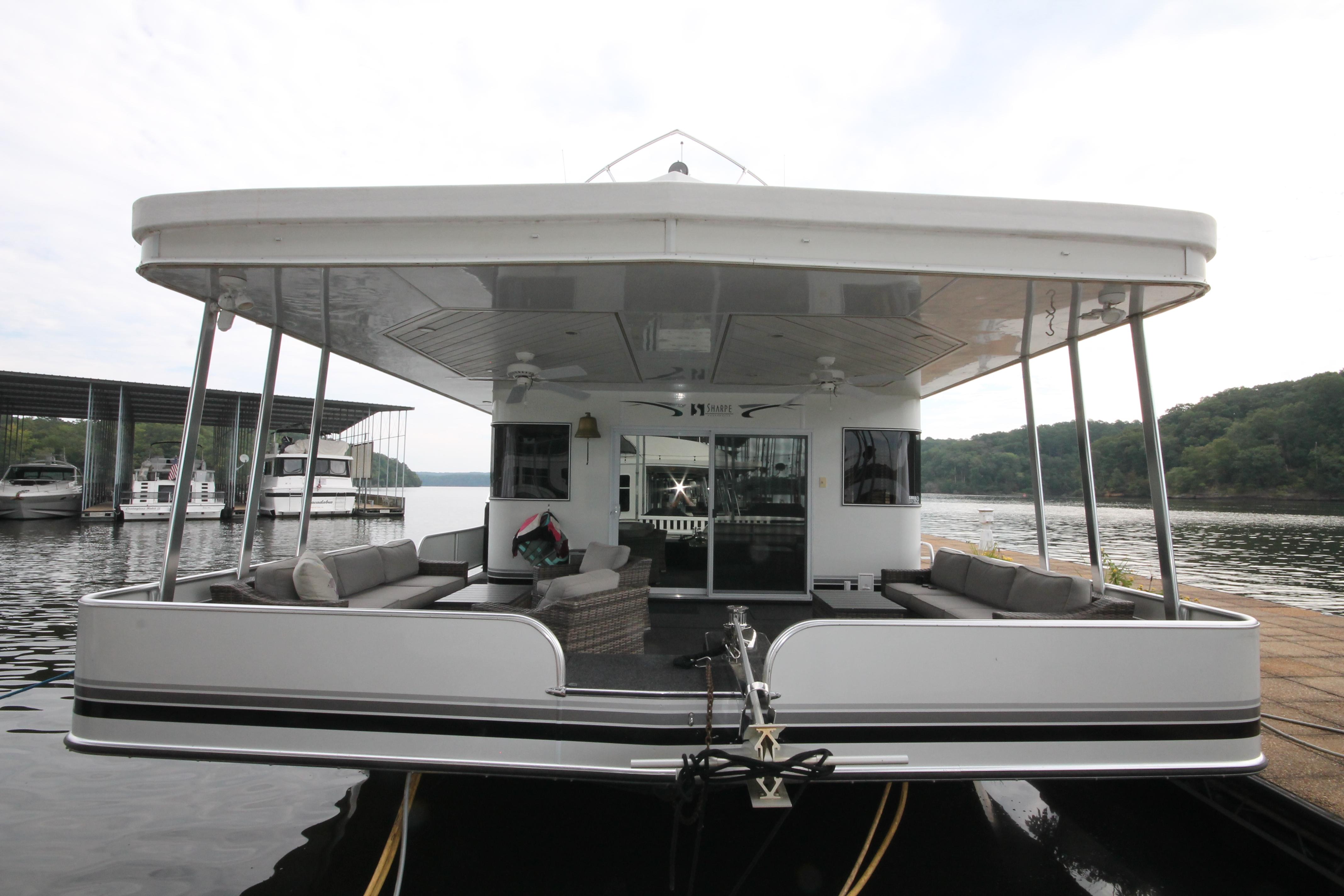 2008 Sharpe 105 Custom Houseboat docked on a serene lake.