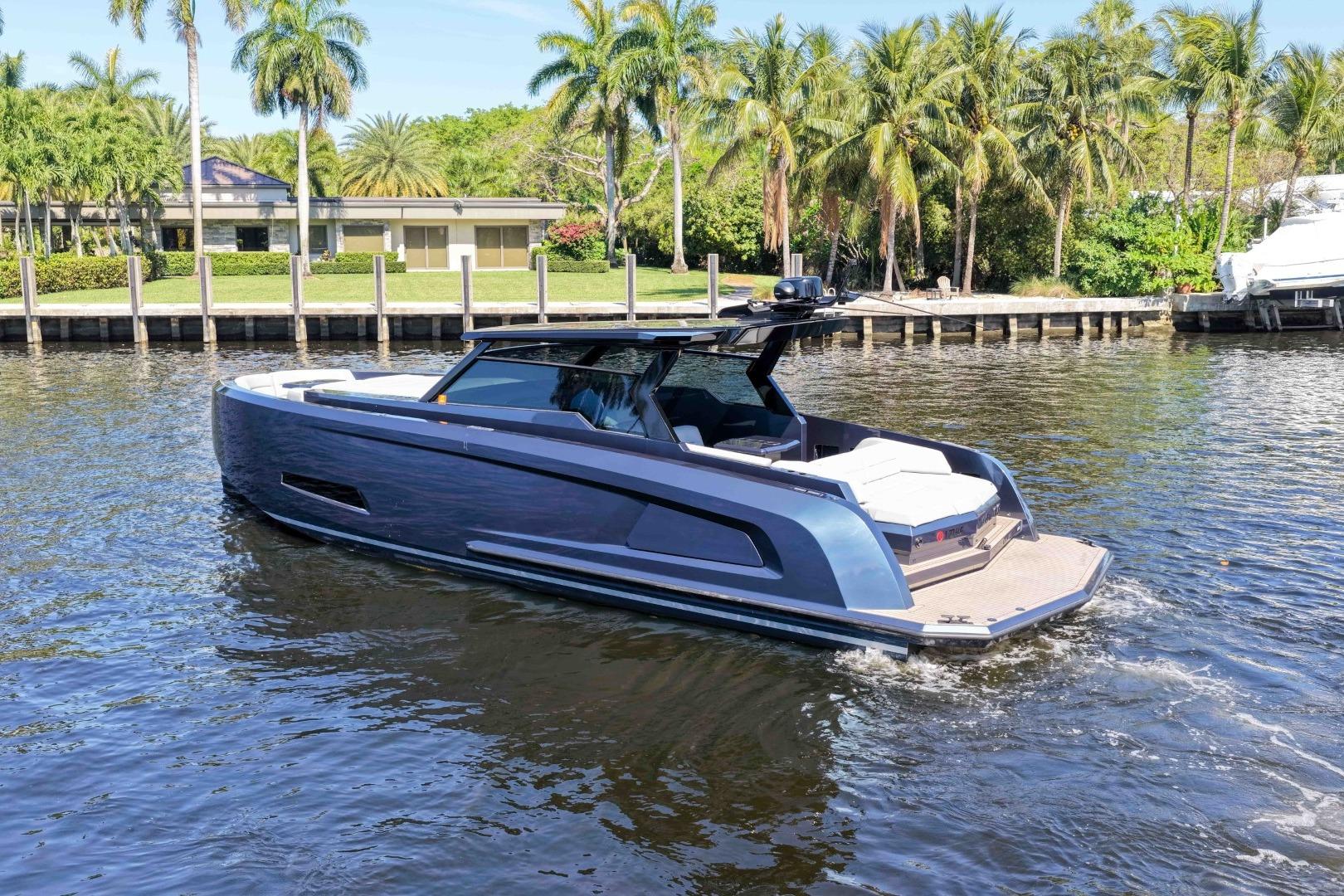 2022 Vanquish Yachts VQ45 cruising on a sunny day, surrounded by palm trees.