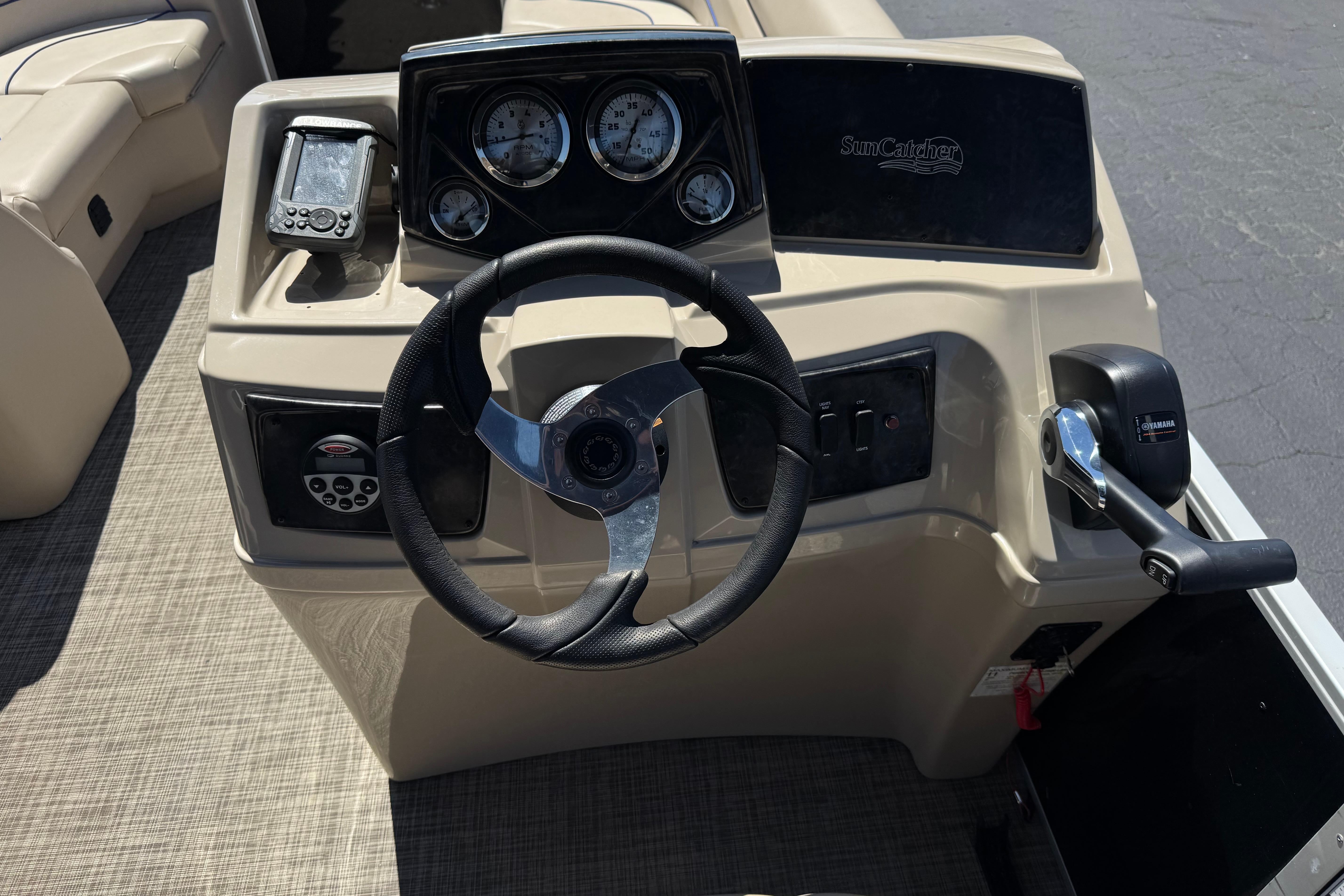 Steering console of 2021 SunCatcher Select 20RCX boat with gauges and controls.