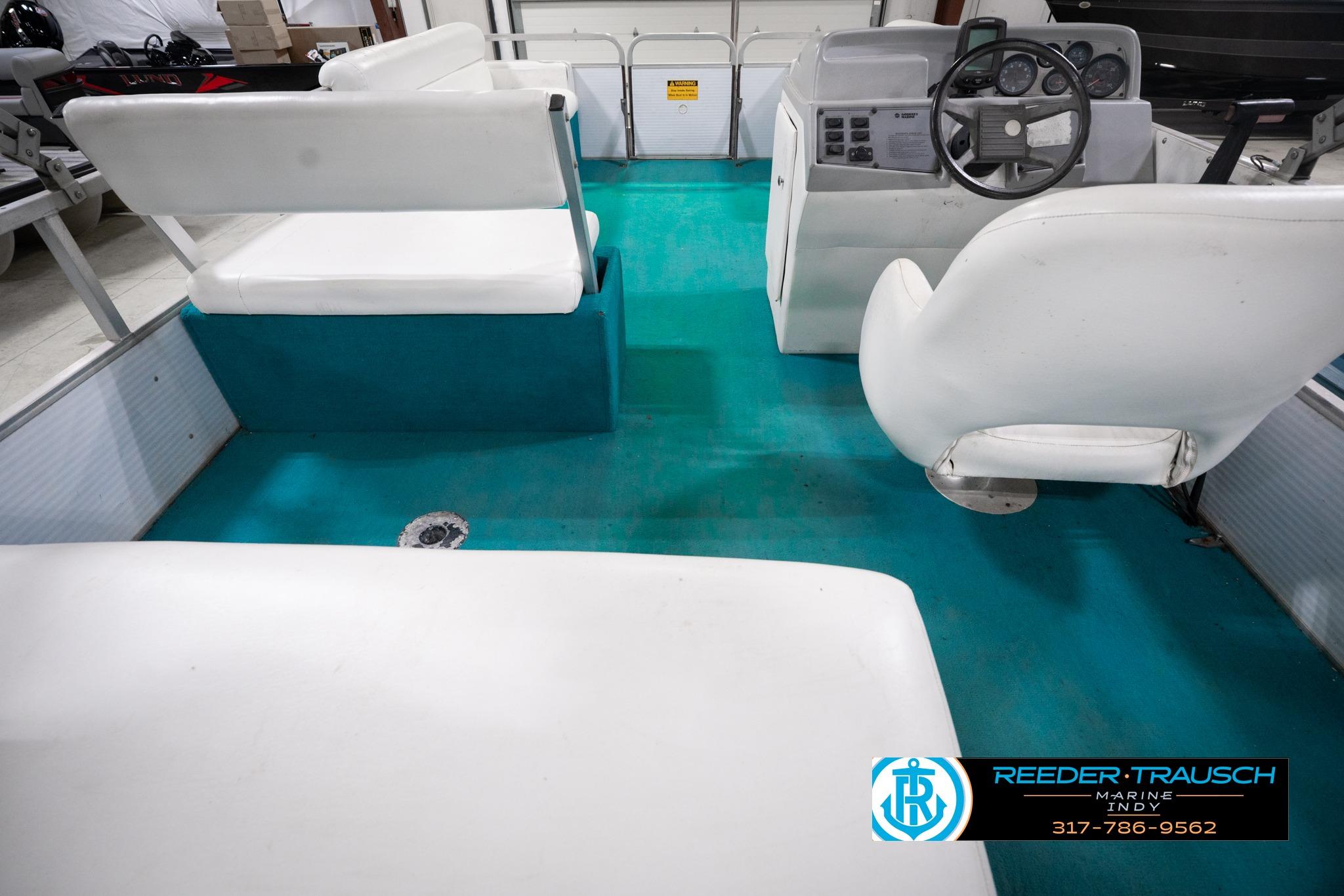 1992 Godfrey Sweetwater boat interior with white seating and teal flooring.