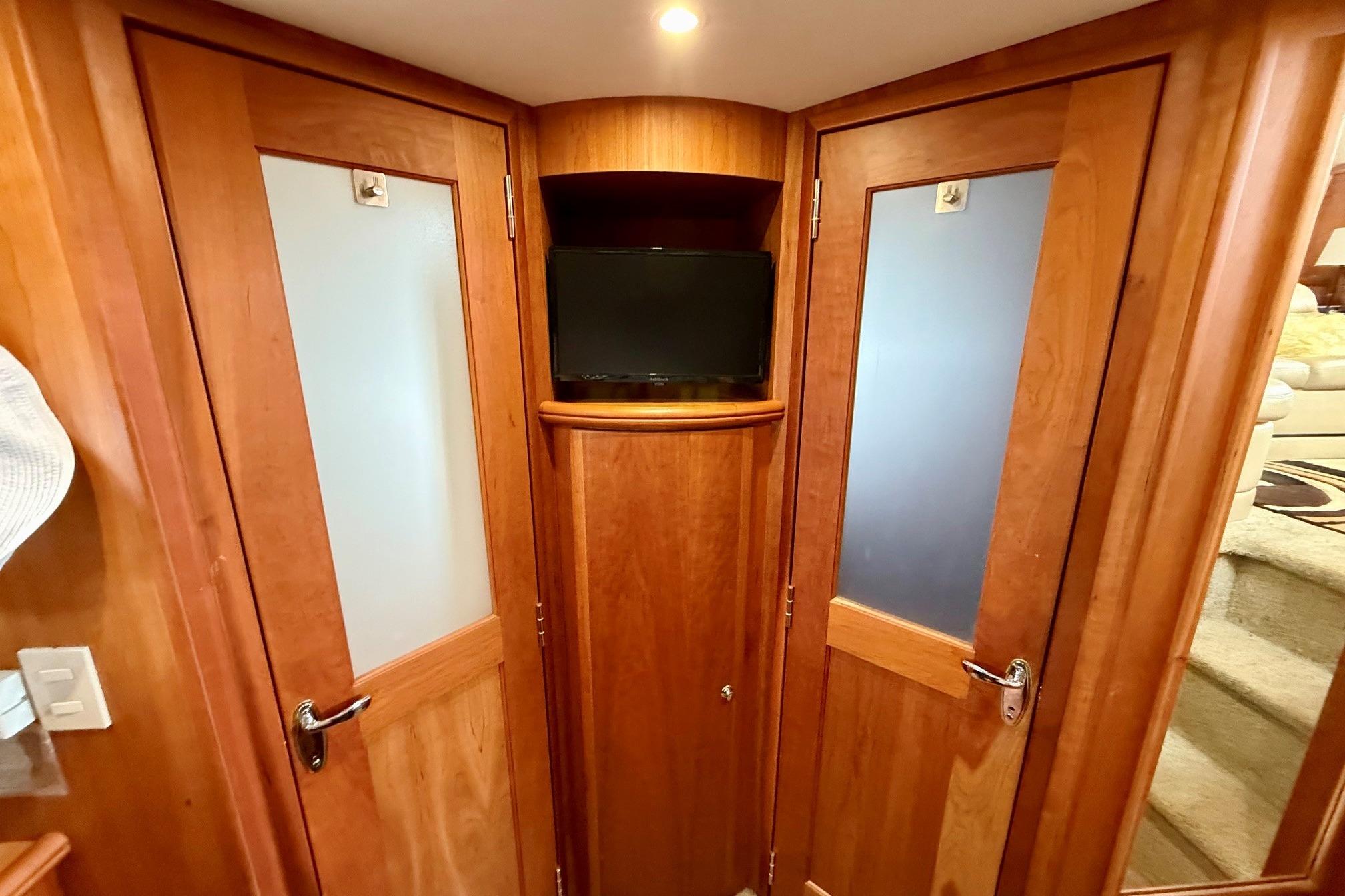 Interior of 2004 Silverton 39 Motor Yacht with wooden doors and a small TV.