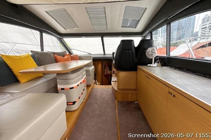 Interior of 2016 Princess V48 yacht with seating, table, and helm station.