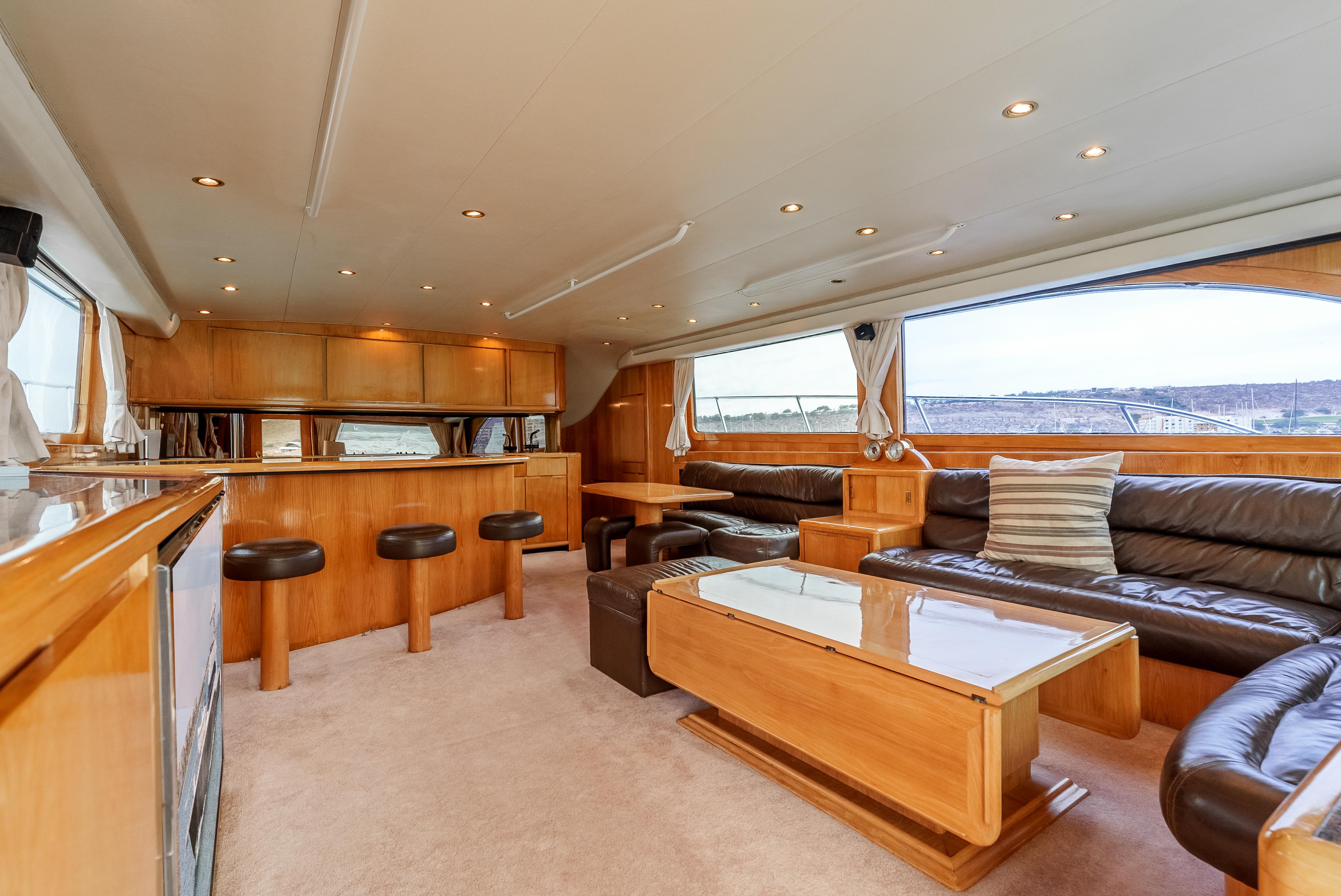 Luxurious interior of a 1995 Donzi 72 Convertible yacht with leather seating and wooden finishes.
