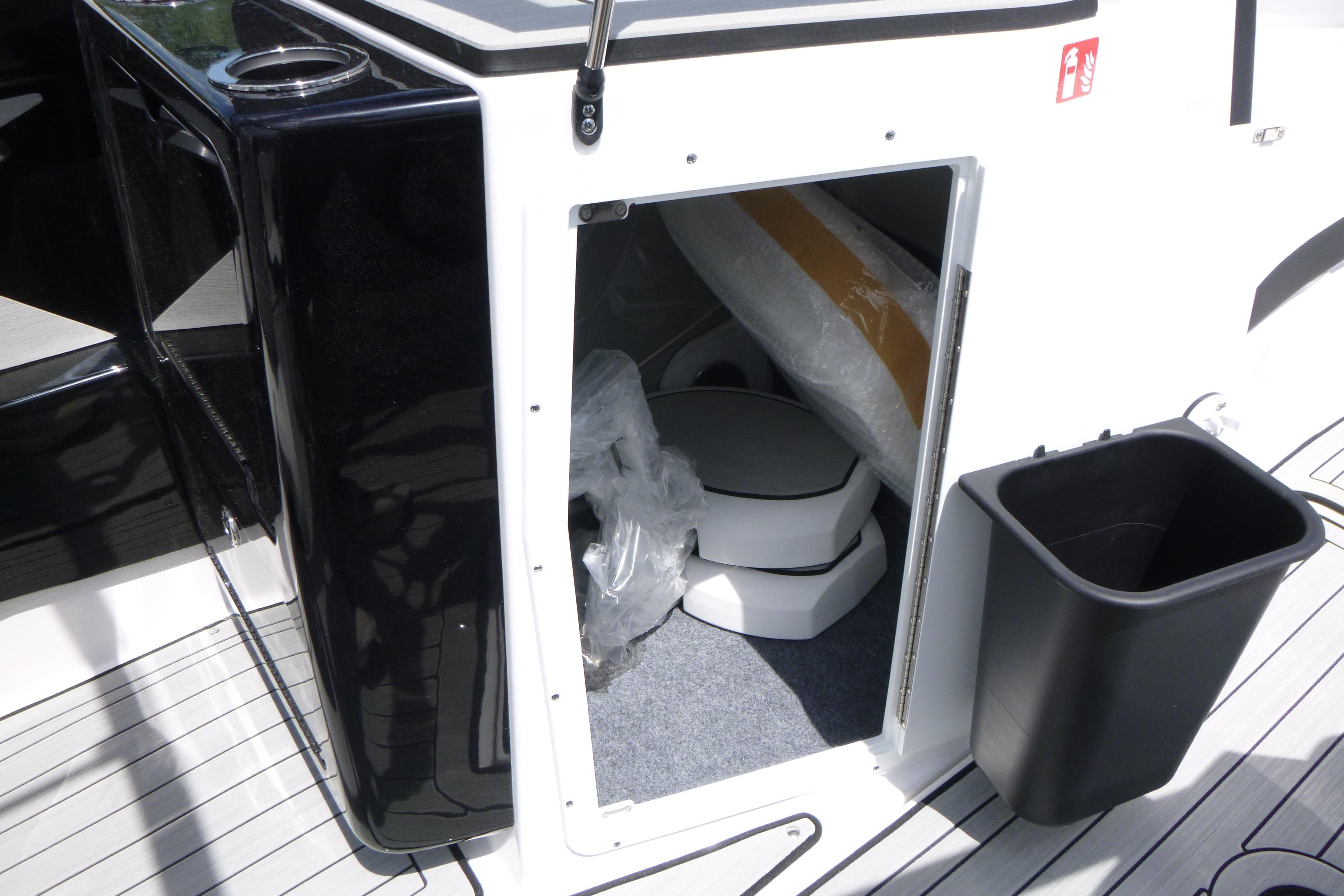 Interior storage compartment of 2026 Yamaha Boats 222S, featuring a compact toilet.