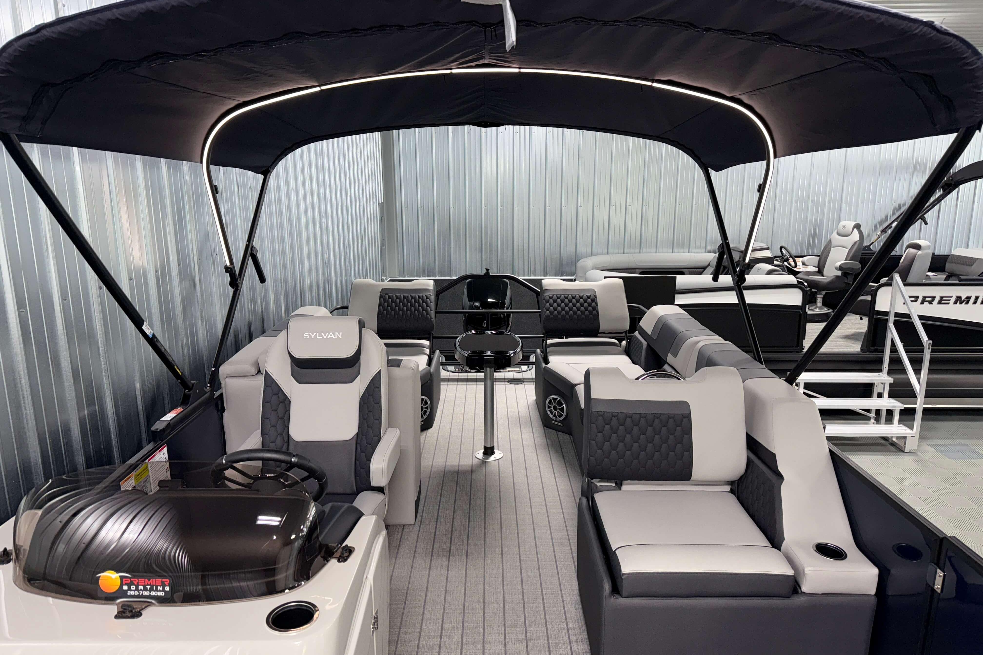 2026 Sylvan L3 SLZ pontoon boat with modern seating and canopy in showroom.