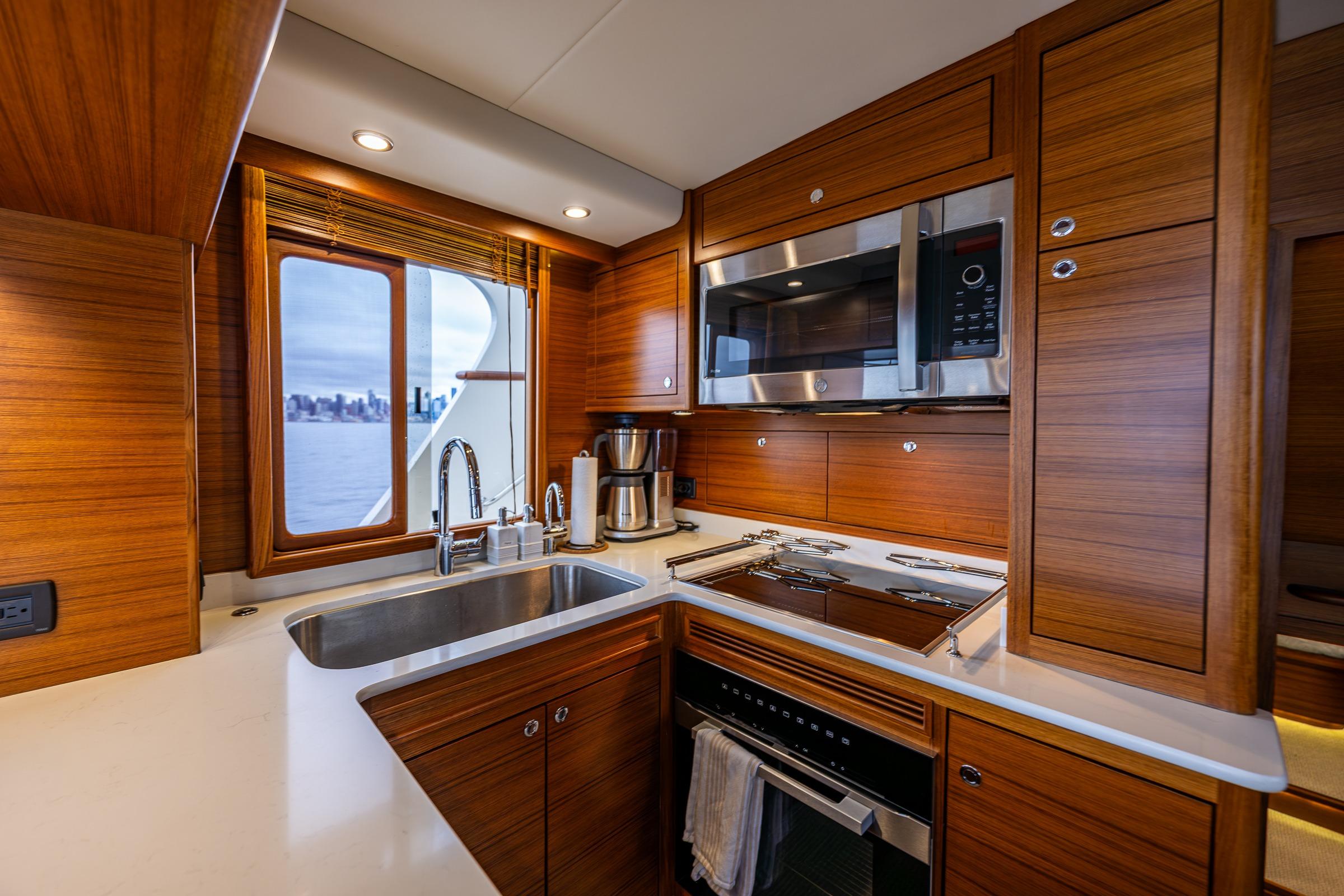 Luxurious kitchen interior of 2026 Fleming 55 Pilothouse yacht with modern appliances.