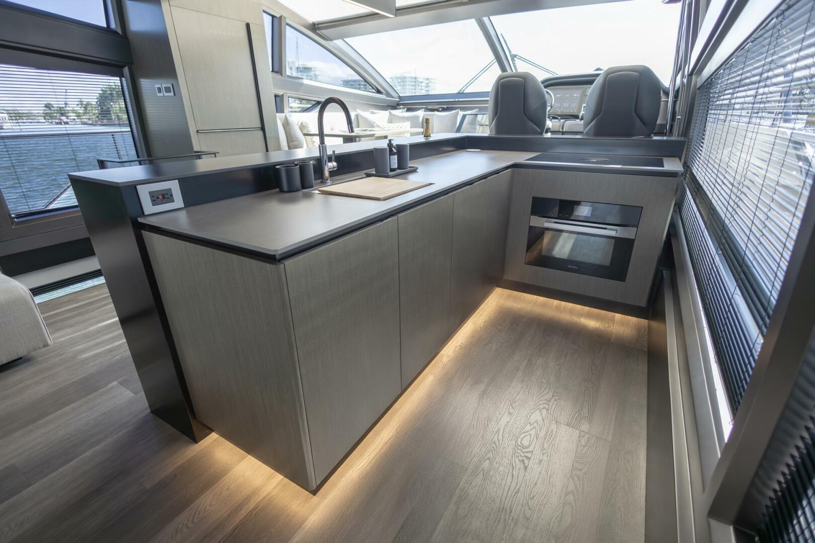 Modern kitchen interior on 2023 Pearl 72 yacht, featuring sleek design and ambient lighting.