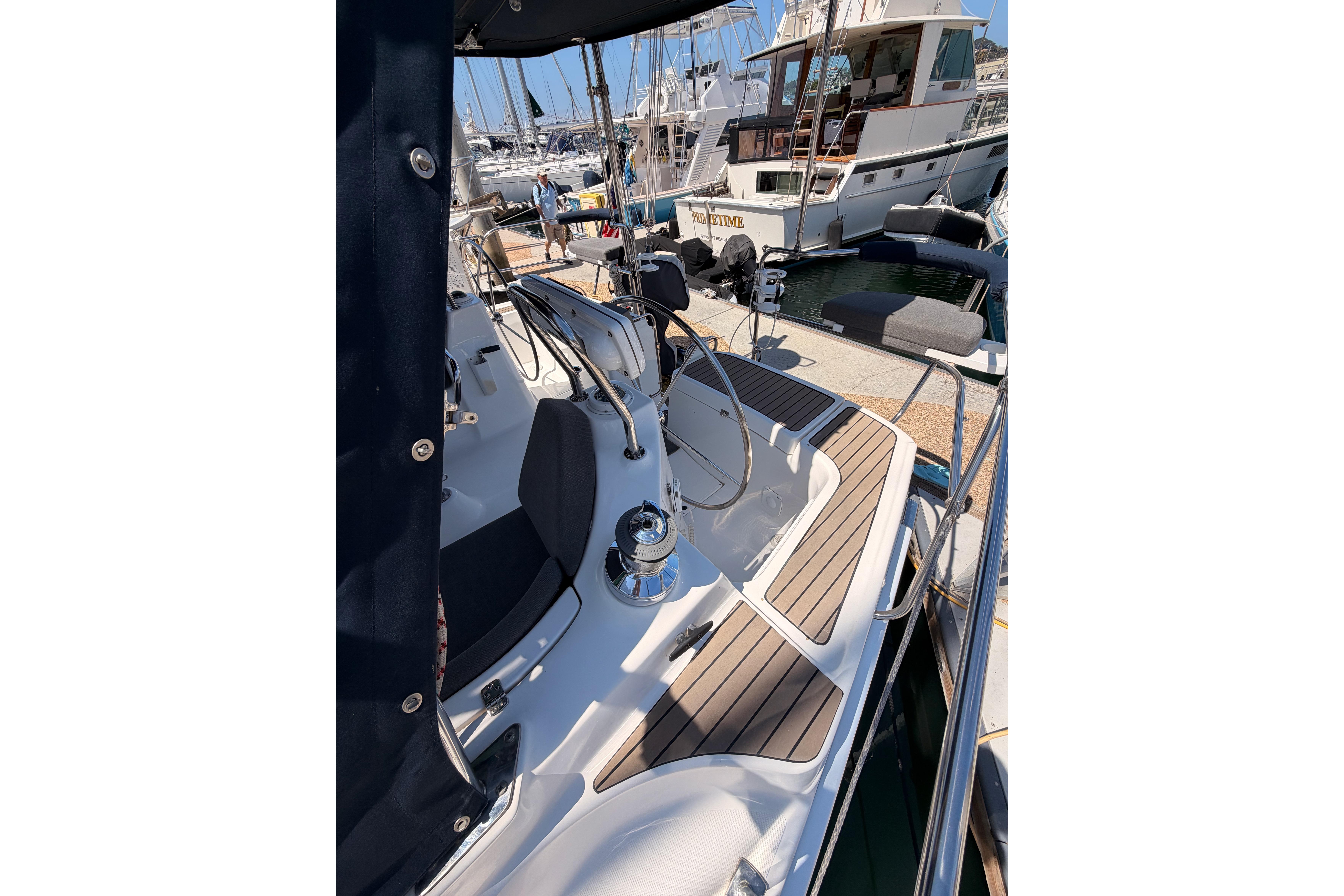 2008 Hunter 45 Deck Salon yacht cockpit with wooden flooring and steering wheel at marina.