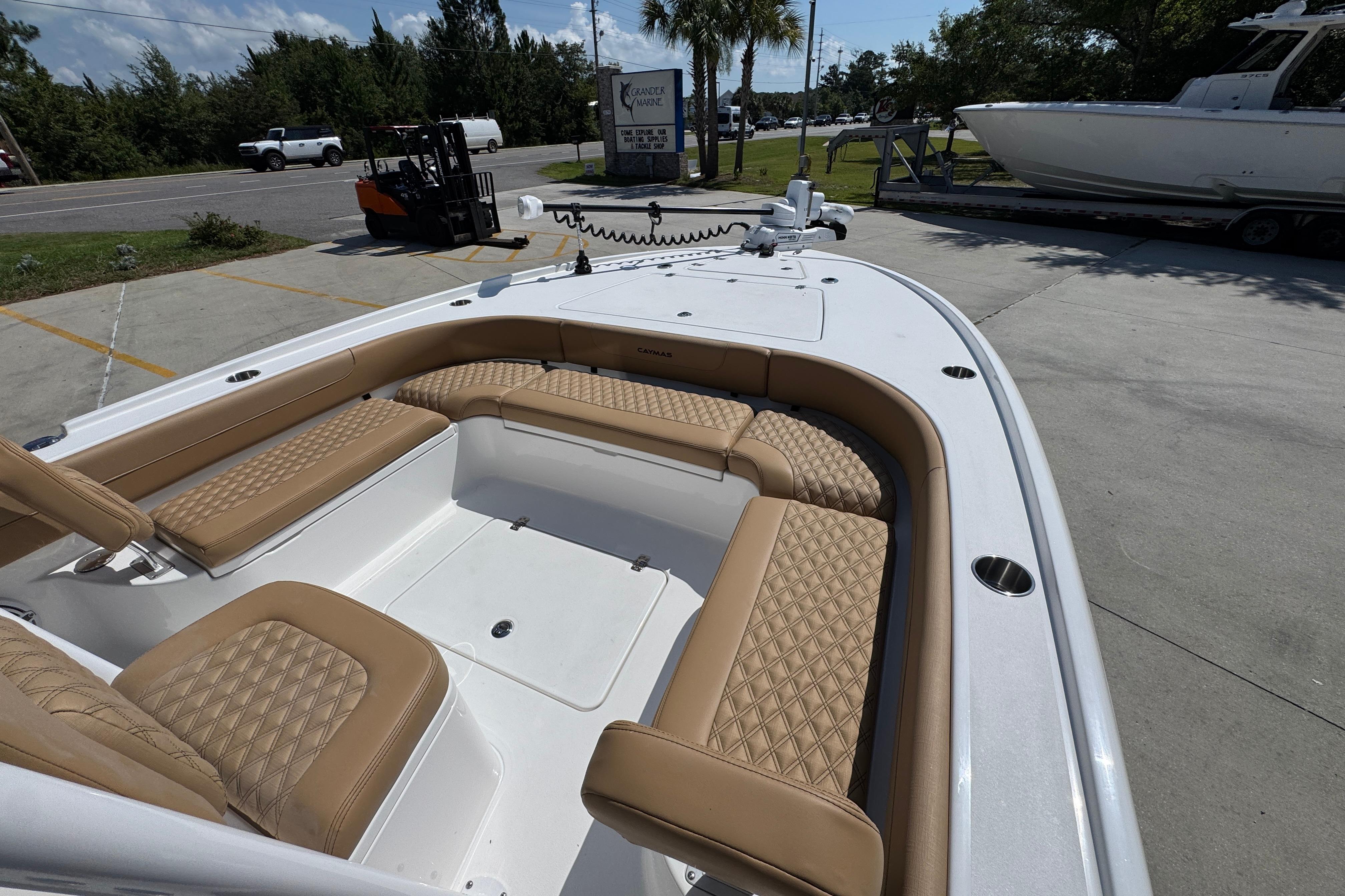 2027 Caymas 26 HB boat with tan cushioned seating, parked outdoors.